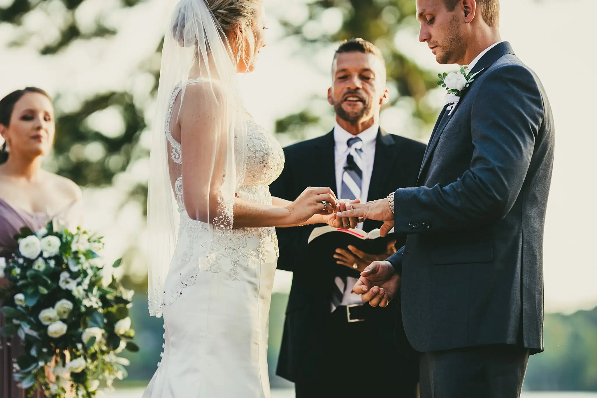 Wedding Ceremony: the couple exchanging rings, close, at their wedding at Houston Lake Country Club in Perry, GA