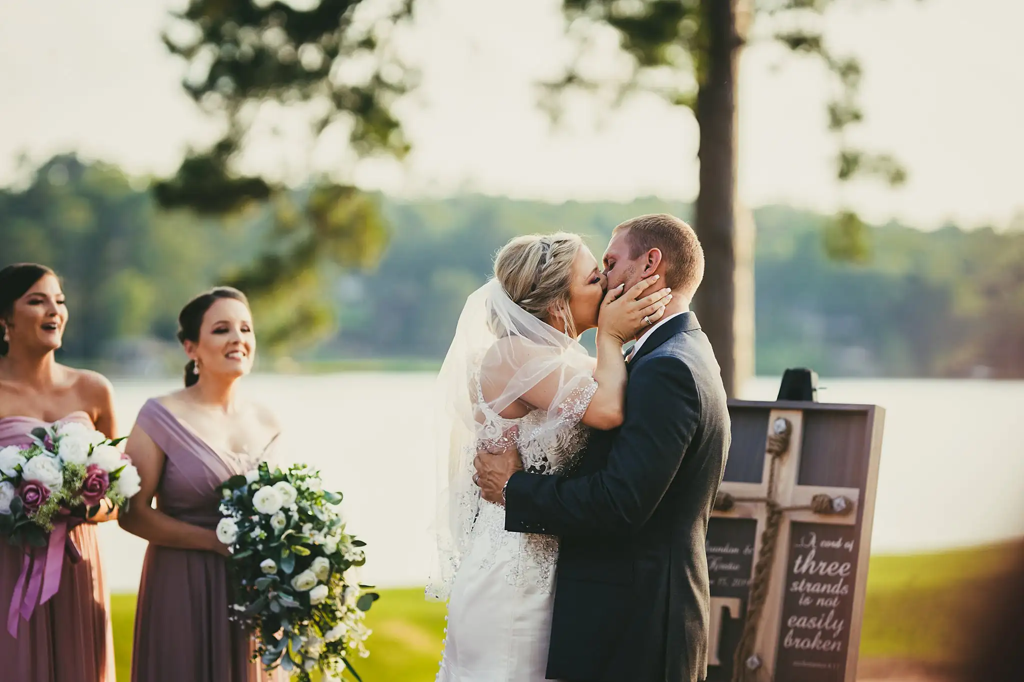 Wedding Ceremony: the first kiss, her bridesmaids beside her, at their wedding at Houston Lake Country Club in Perry, GA