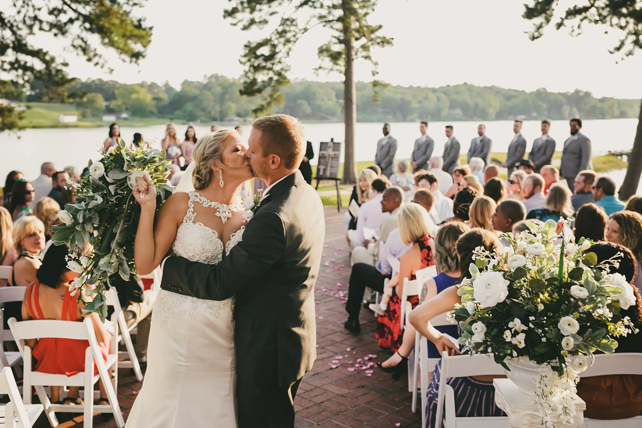 Recessional: the couple kissing as they leave the aisle, at their wedding at Houston Lake Country Club in Perry, GA