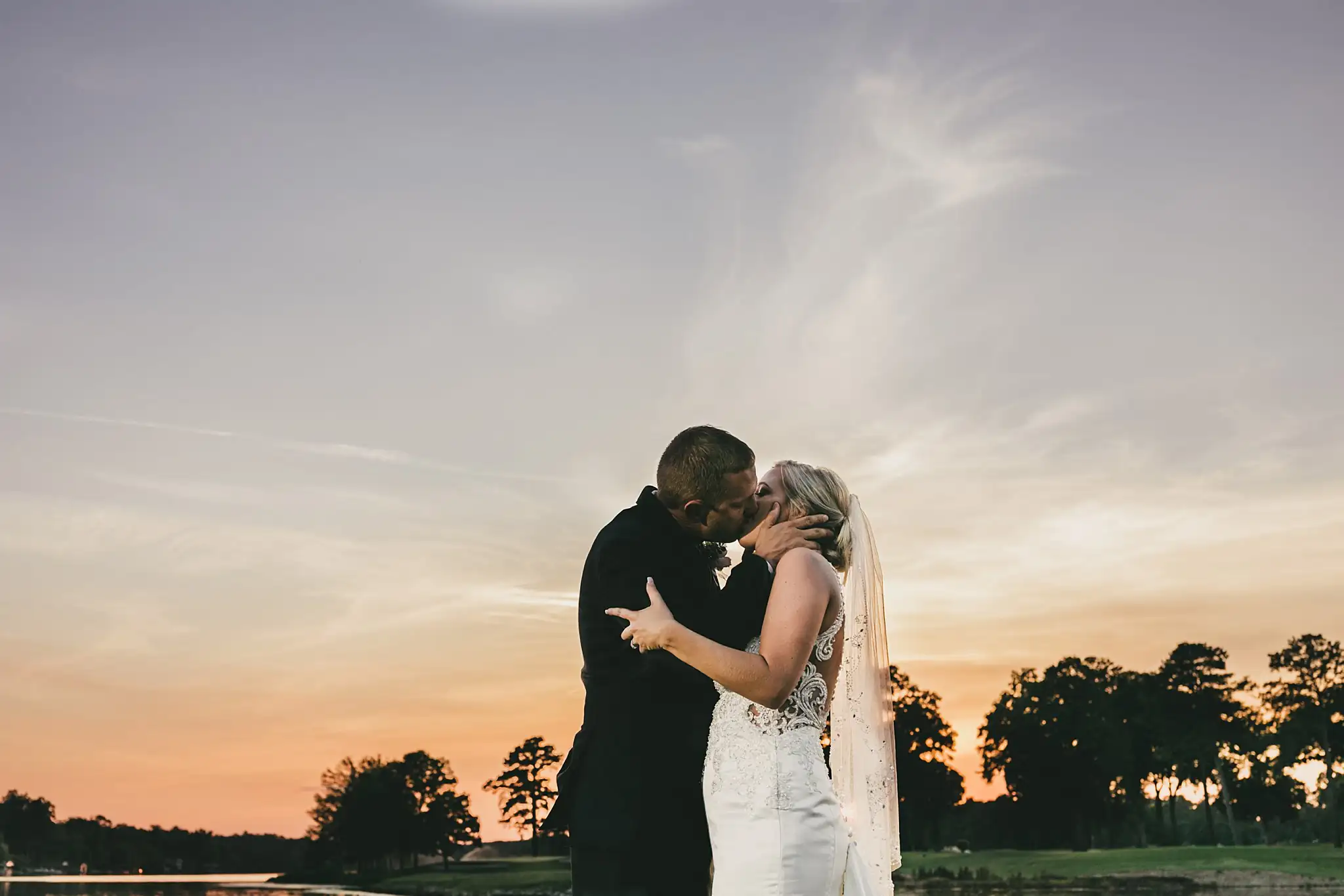 Wedding Formals: the couple silhouetted against the sunset, at their wedding at Houston Lake Country Club in Perry, GA