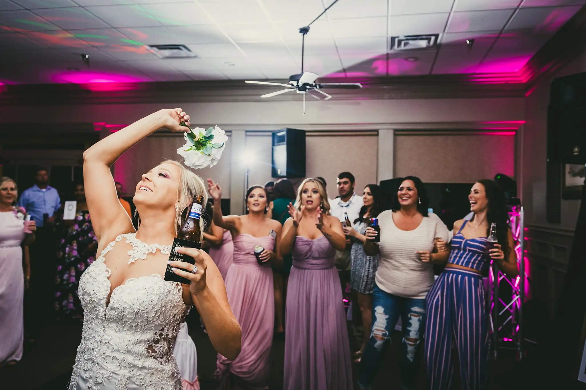 Bouquet Toss: the bride turning to toss her bouquet, at their wedding at Houston Lake Country Club in Perry, GA