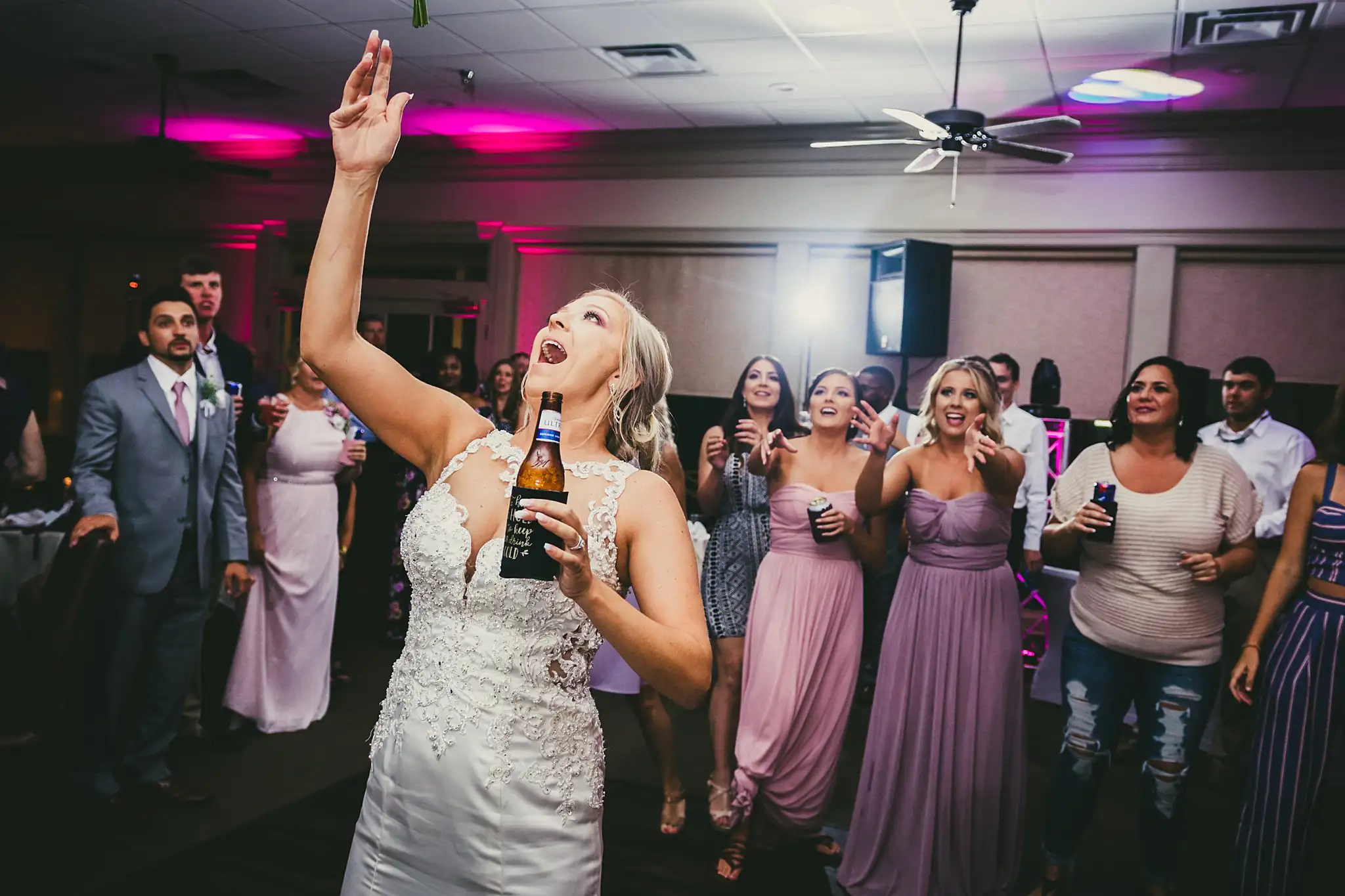 Bouquet Toss: the bride's arm up as the bouquet flies, at their wedding at Houston Lake Country Club in Perry, GA