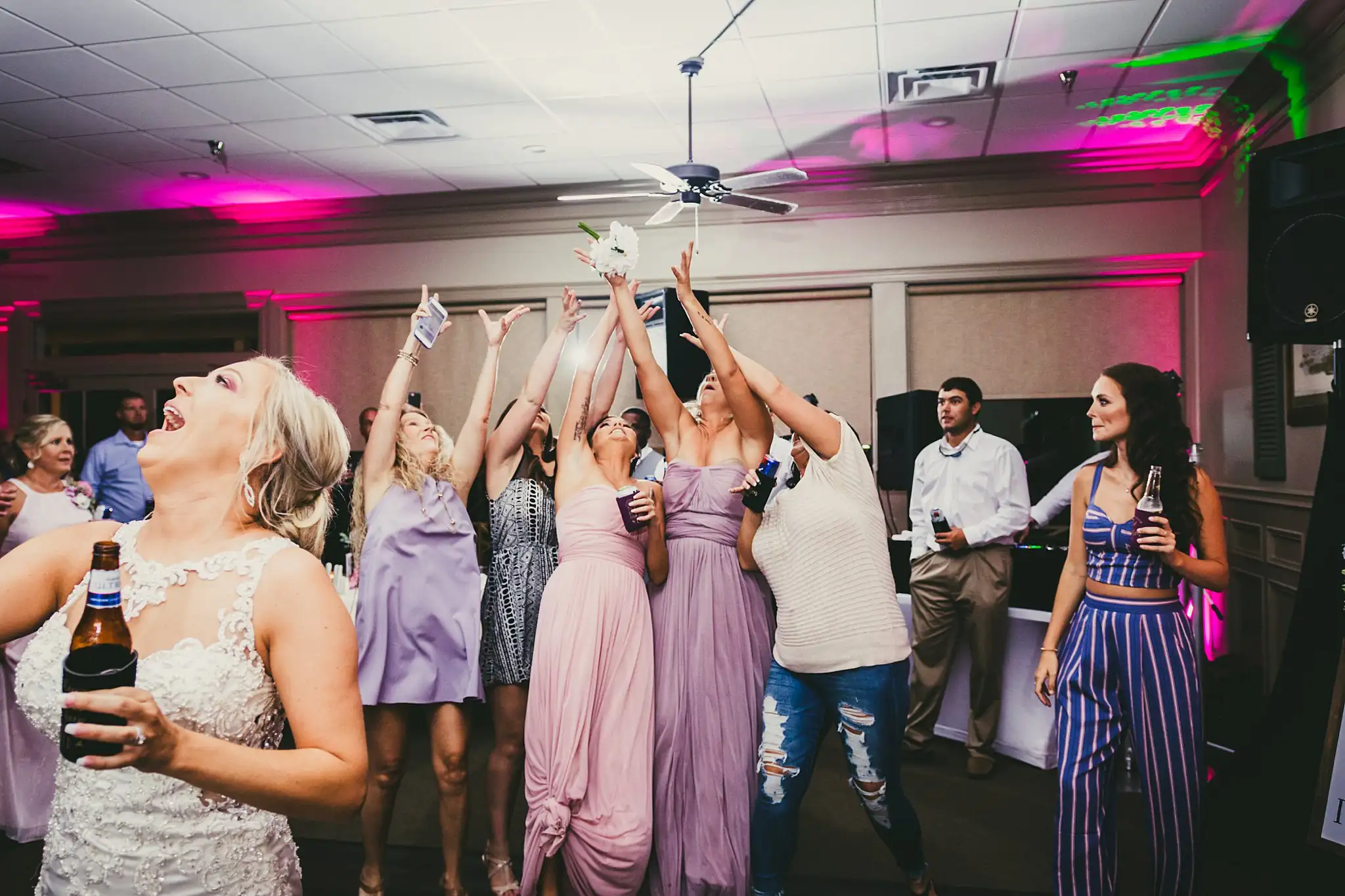 Bouquet Toss: the guests reaching for the bouquet, at their wedding at Houston Lake Country Club in Perry, GA