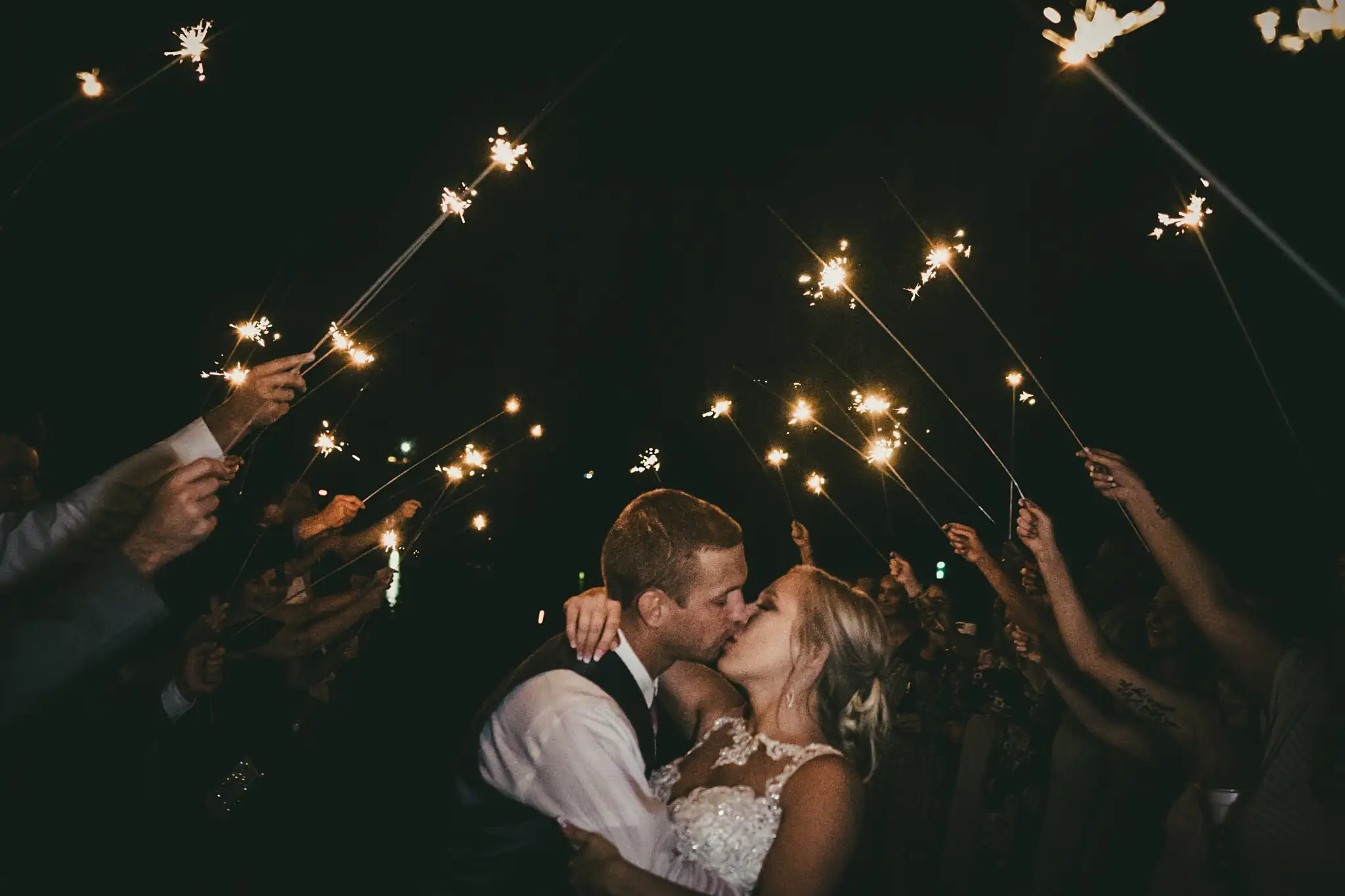 Sparkler Exit: the couple kissing under the sparklers, at their wedding at Houston Lake Country Club in Perry, GA