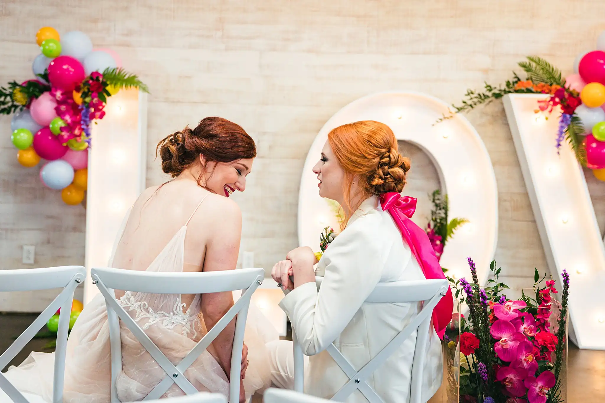 AtlantaWeddingPhotographers_1233.jpg Wedding Formals: the couple seated before the lit letters, at a Whimsically in Love LGBTQ Wedding styled shoot at Brick and Ivey in Marietta, GA