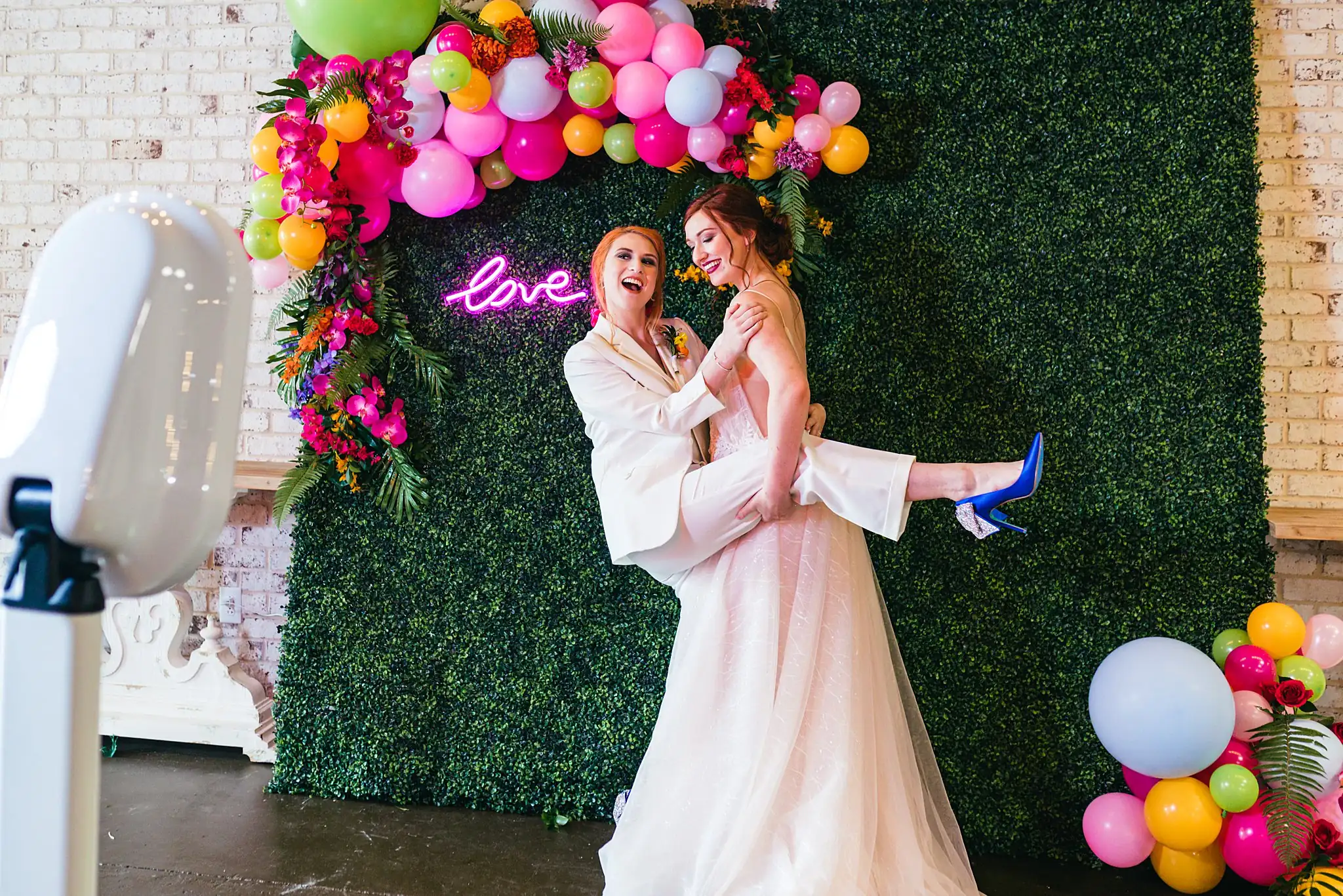 AtlantaWeddingPhotographers_1248.jpg Wedding Formals: one bride lifting the other, neon behind, at a Whimsically in Love LGBTQ Wedding styled shoot at Brick and Ivey in Marietta, GA