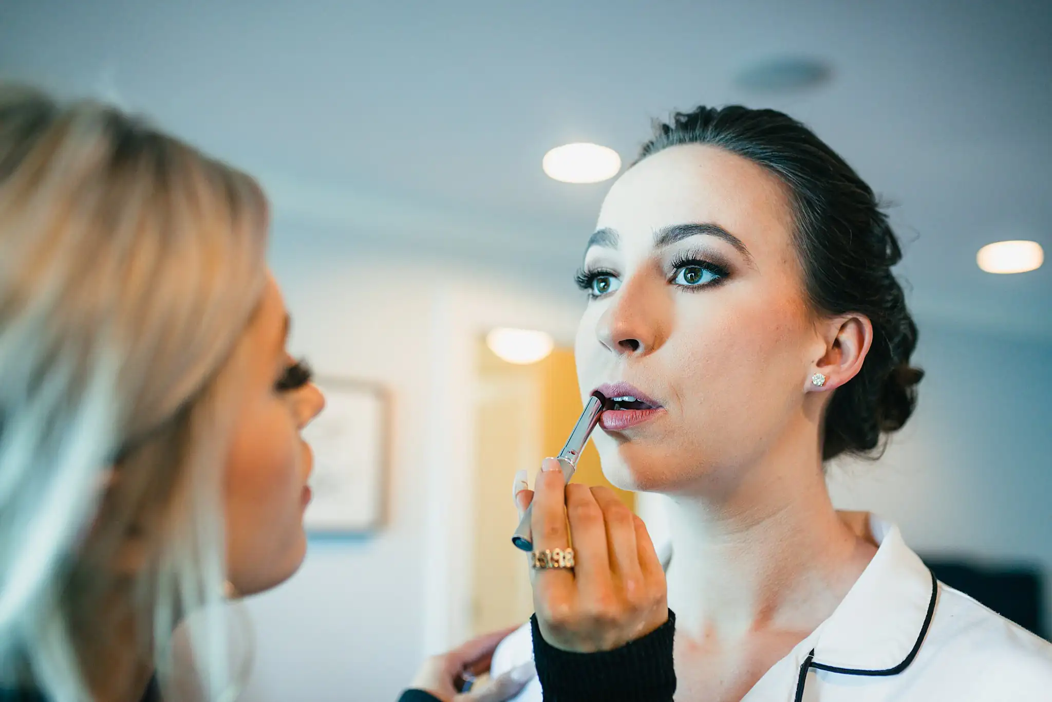 Getting Ready: the bride's lipstick being finished, before their wedding at Ashton Gardens Atlanta in Sugar Hill, GA
