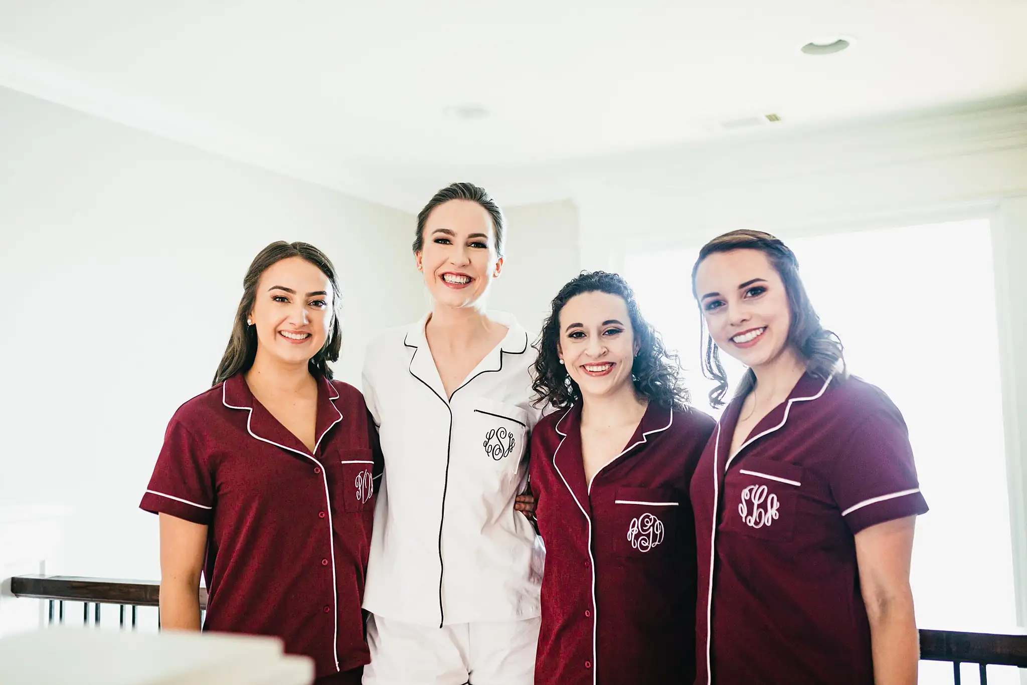 Getting Ready: the bride and bridesmaids in matching burgundy pyjamas, before their wedding at Ashton Gardens Atlanta in Sugar Hill, GA