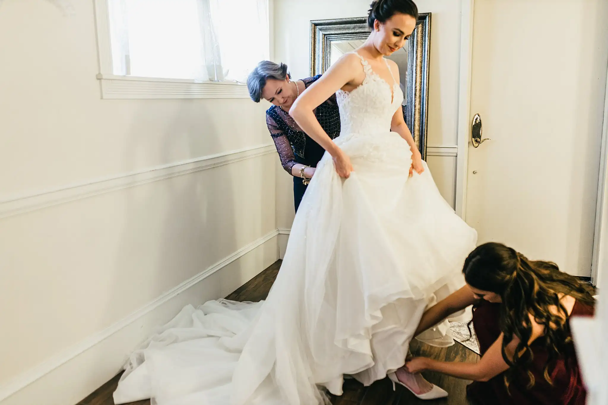 Getting Ready: the bride's ballgown skirt being arranged, before their wedding at Ashton Gardens Atlanta in Sugar Hill, GA