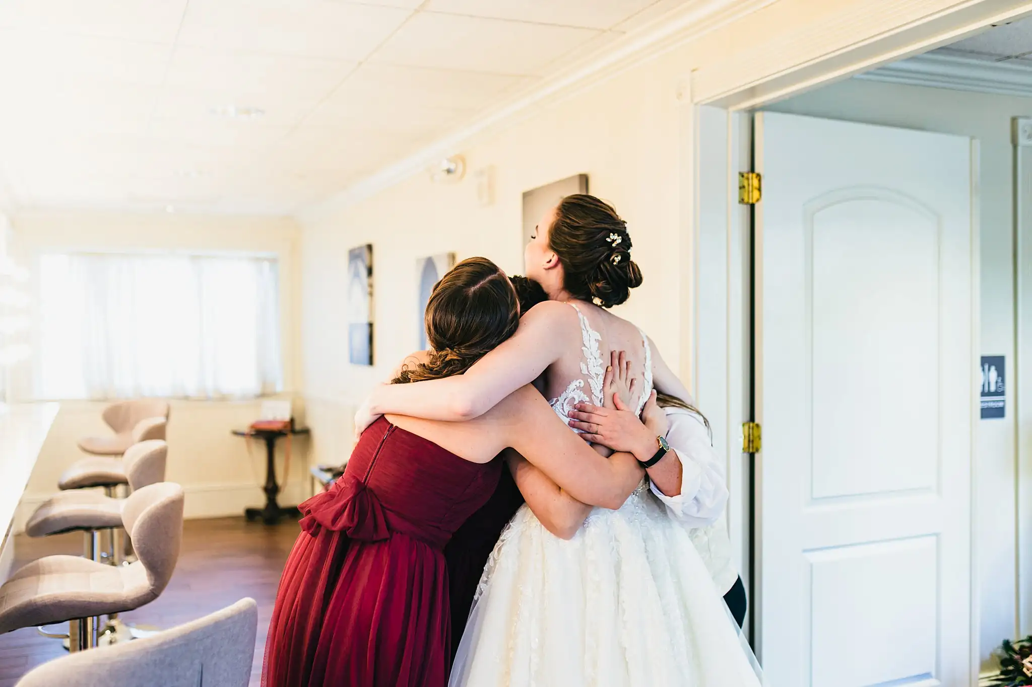 Getting Ready: the bride hugging a bridesmaid, before their wedding at Ashton Gardens Atlanta in Sugar Hill, GA