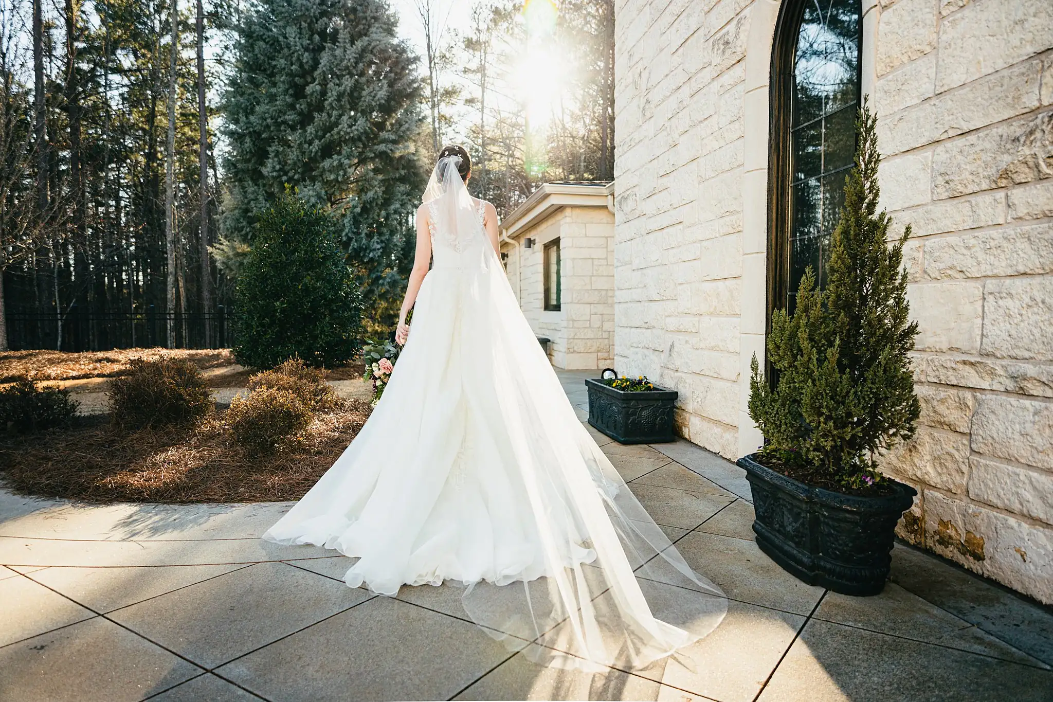 Bridal Portraits: the bride's train spread across the chapel terrace, at their wedding at Ashton Gardens Atlanta in Sugar Hill, GA