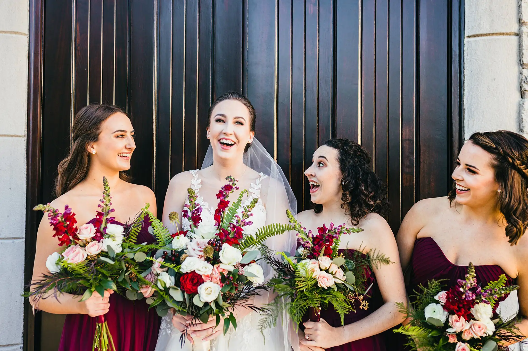 Wedding Party: the bridesmaids laughing with their bouquets, at their wedding at Ashton Gardens Atlanta in Sugar Hill, GA