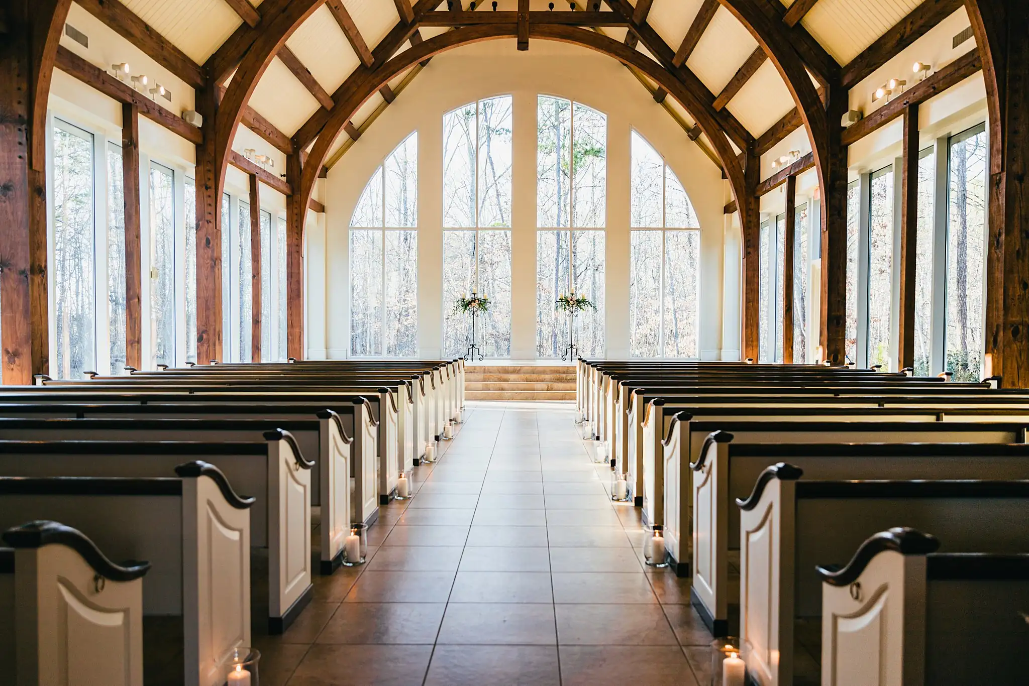 Wedding Ceremony: the chapel's timber trusses and glass altar wall, at a wedding at Ashton Gardens Atlanta in Sugar Hill, GA