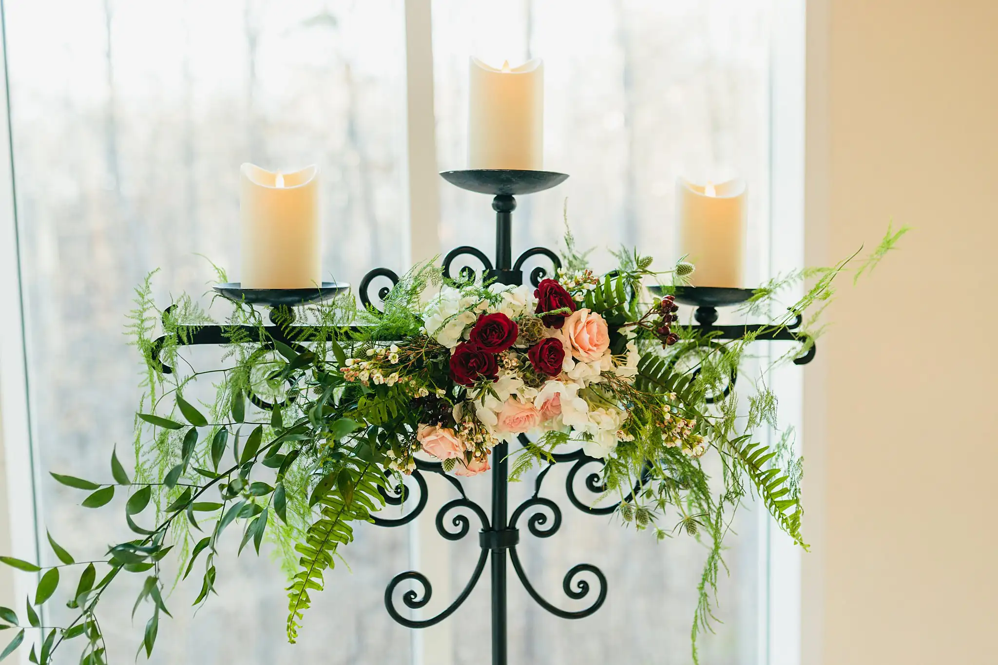 Wedding Florals: a candelabrum dressed with burgundy and blush flowers, at a wedding at Ashton Gardens Atlanta in Sugar Hill, GA