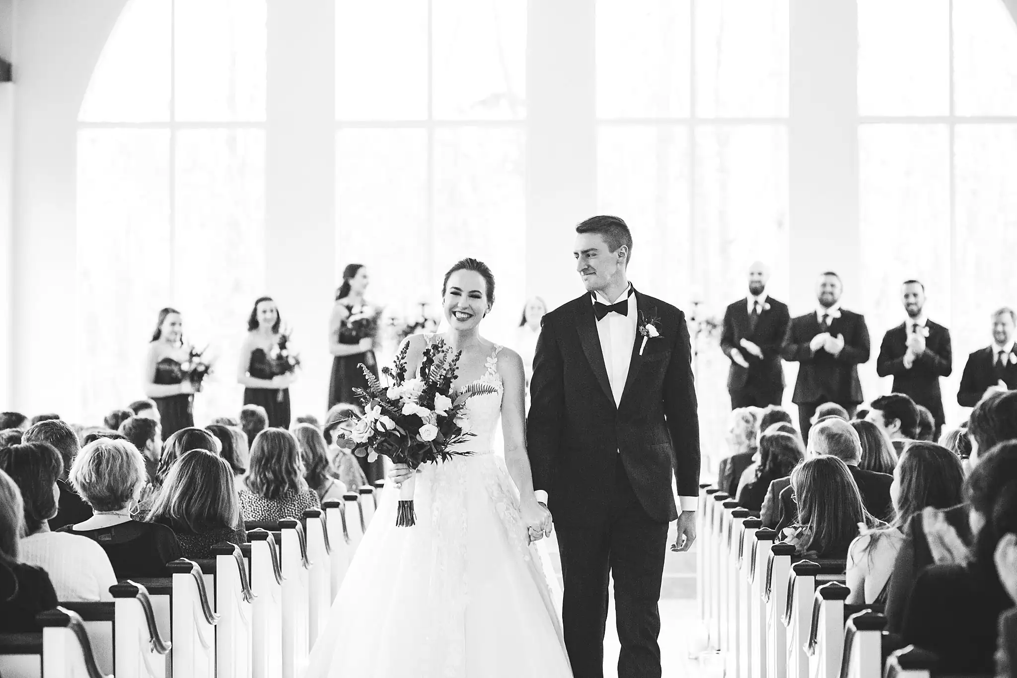 Recessional: the couple leaving up the aisle, in black and white, at their wedding at Ashton Gardens Atlanta in Sugar Hill, GA