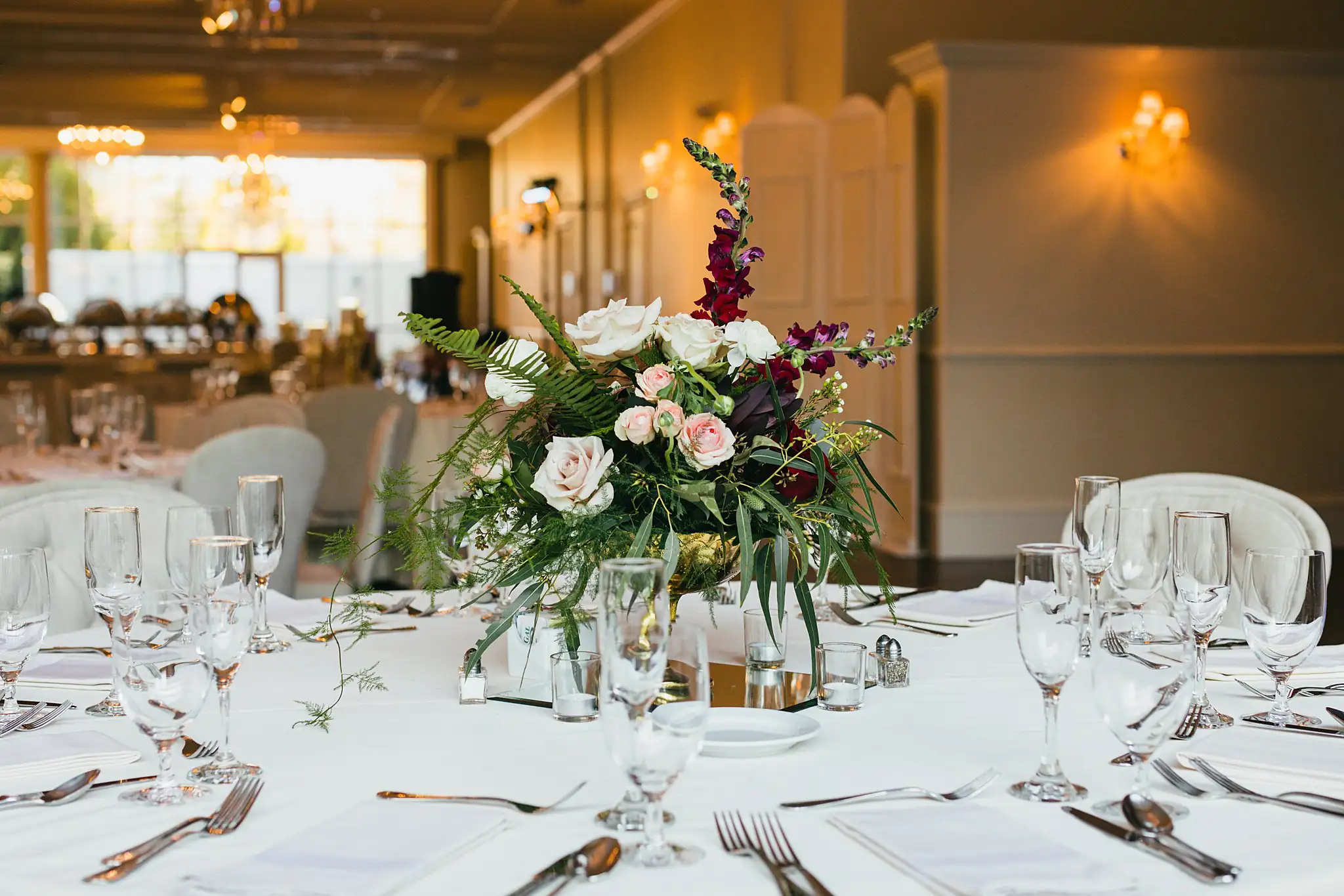 Reception Details: the reception tables set under warm light, at their wedding at Ashton Gardens Atlanta in Sugar Hill, GA