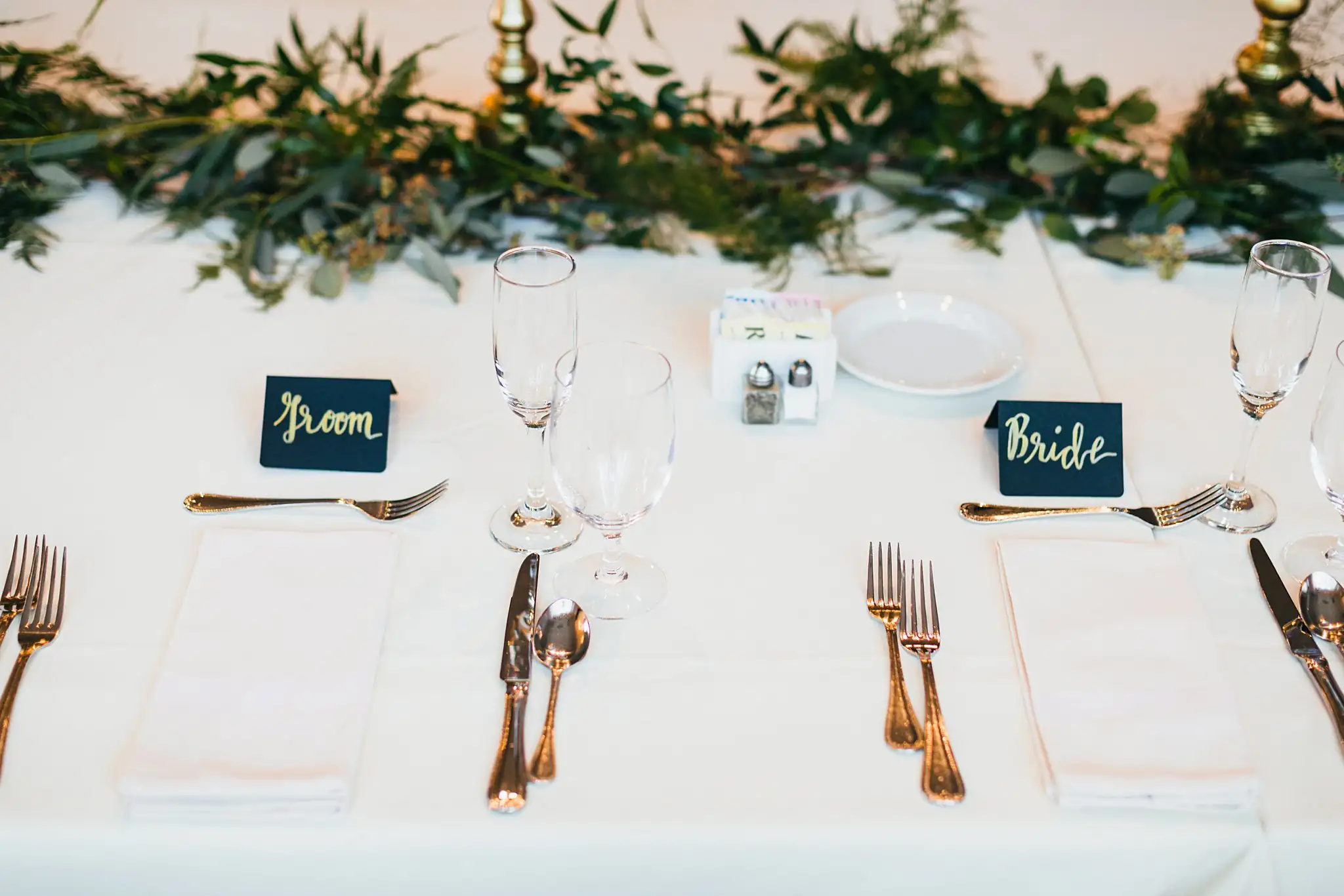 Reception Details: the head table settings and their greenery garland, at their wedding at Ashton Gardens Atlanta in Sugar Hill, GA