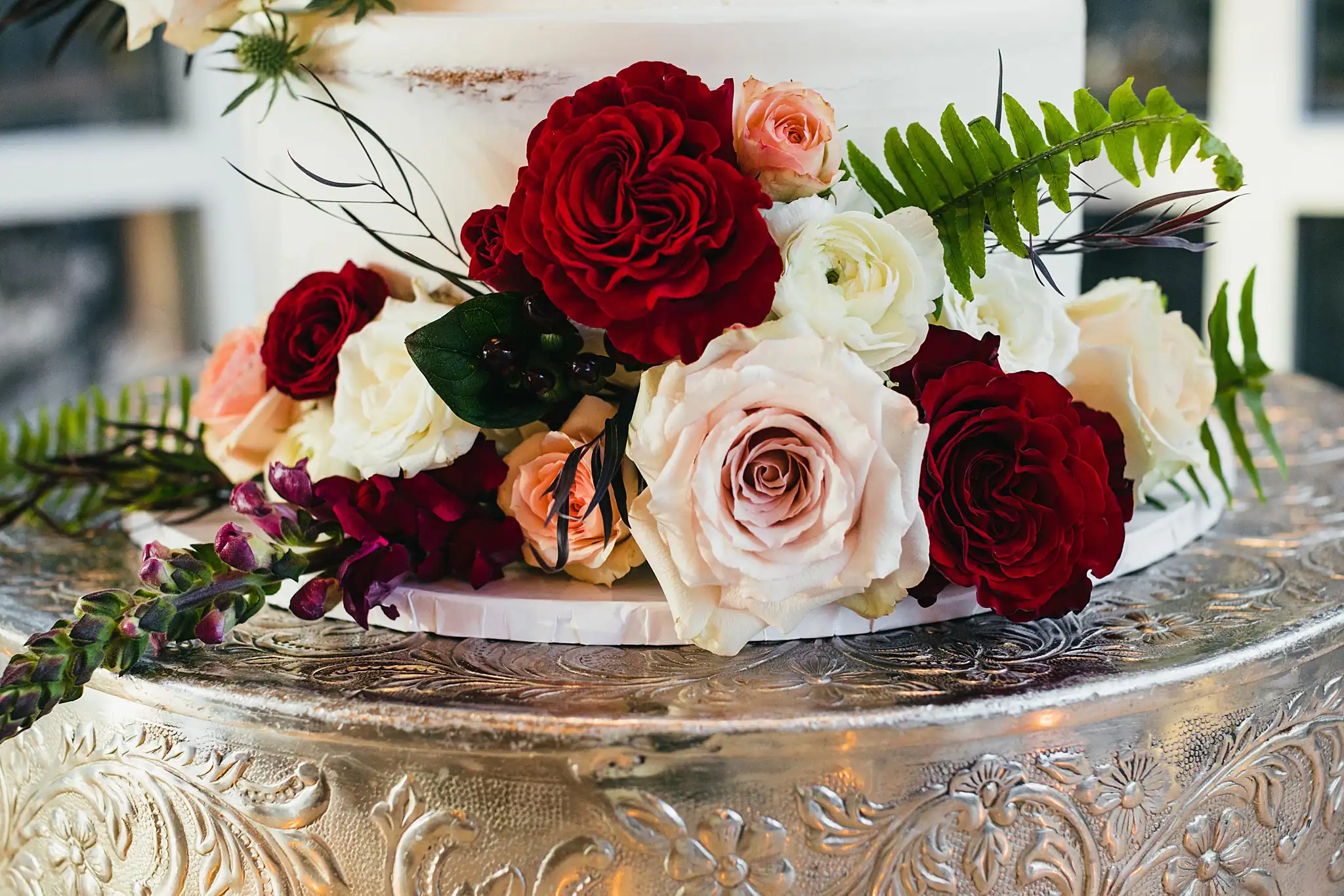 Wedding Florals: red and blush roses on a silver stand, at their wedding at Ashton Gardens Atlanta in Sugar Hill, GA