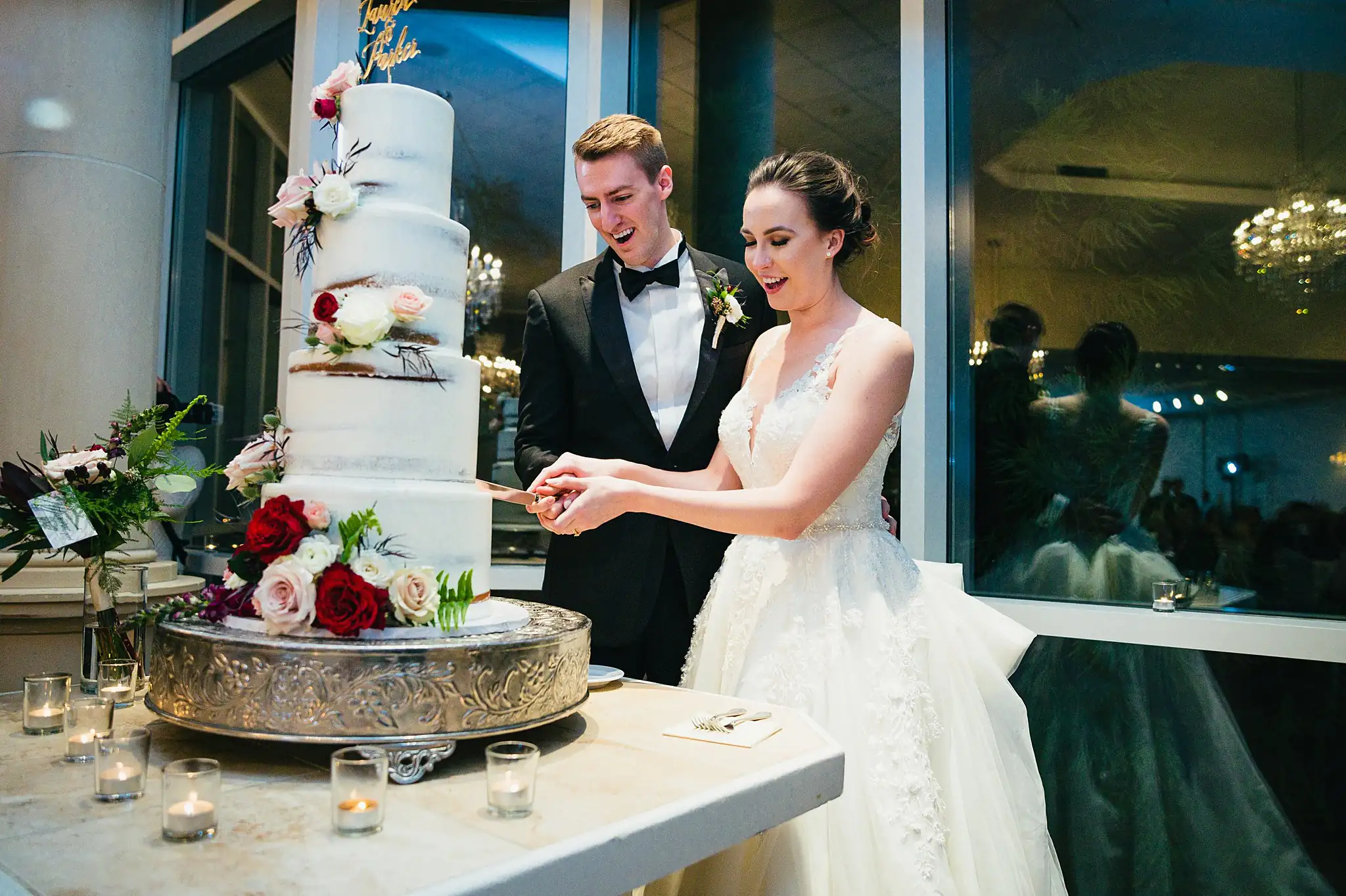 Cake Cutting: the couple cutting their tiered cake, at their wedding at Ashton Gardens Atlanta in Sugar Hill, GA