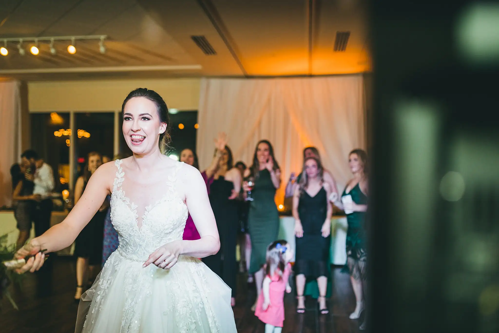 Bouquet Toss: the bride turning to throw her bouquet, at their wedding at Ashton Gardens Atlanta in Sugar Hill, GA