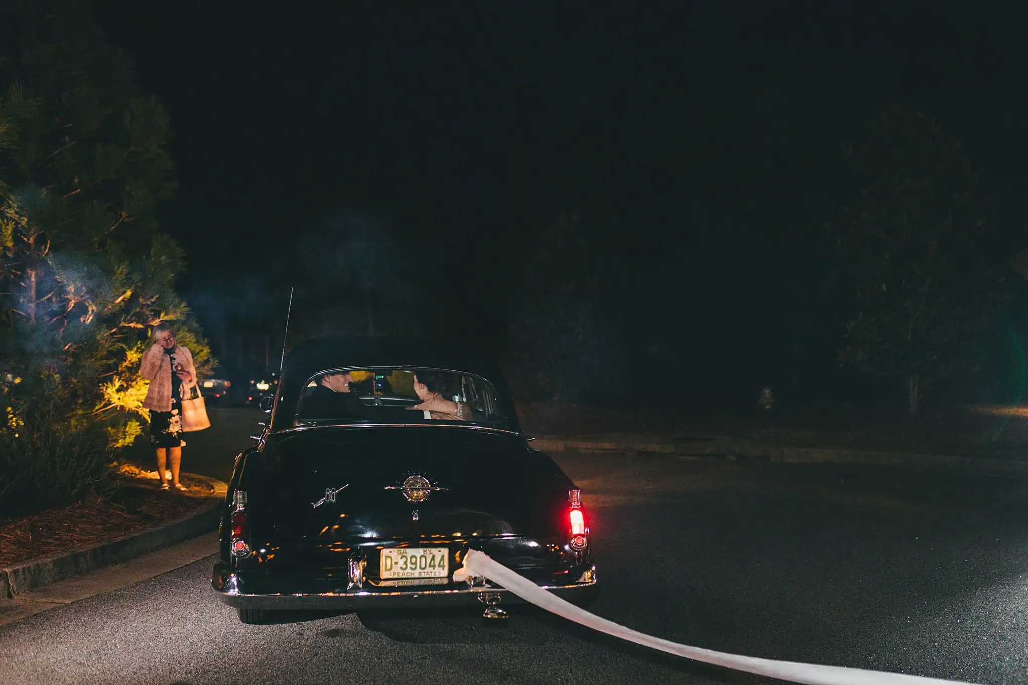 Send-Off: the vintage car pulling away into the night, at their wedding at Ashton Gardens Atlanta in Sugar Hill, GA