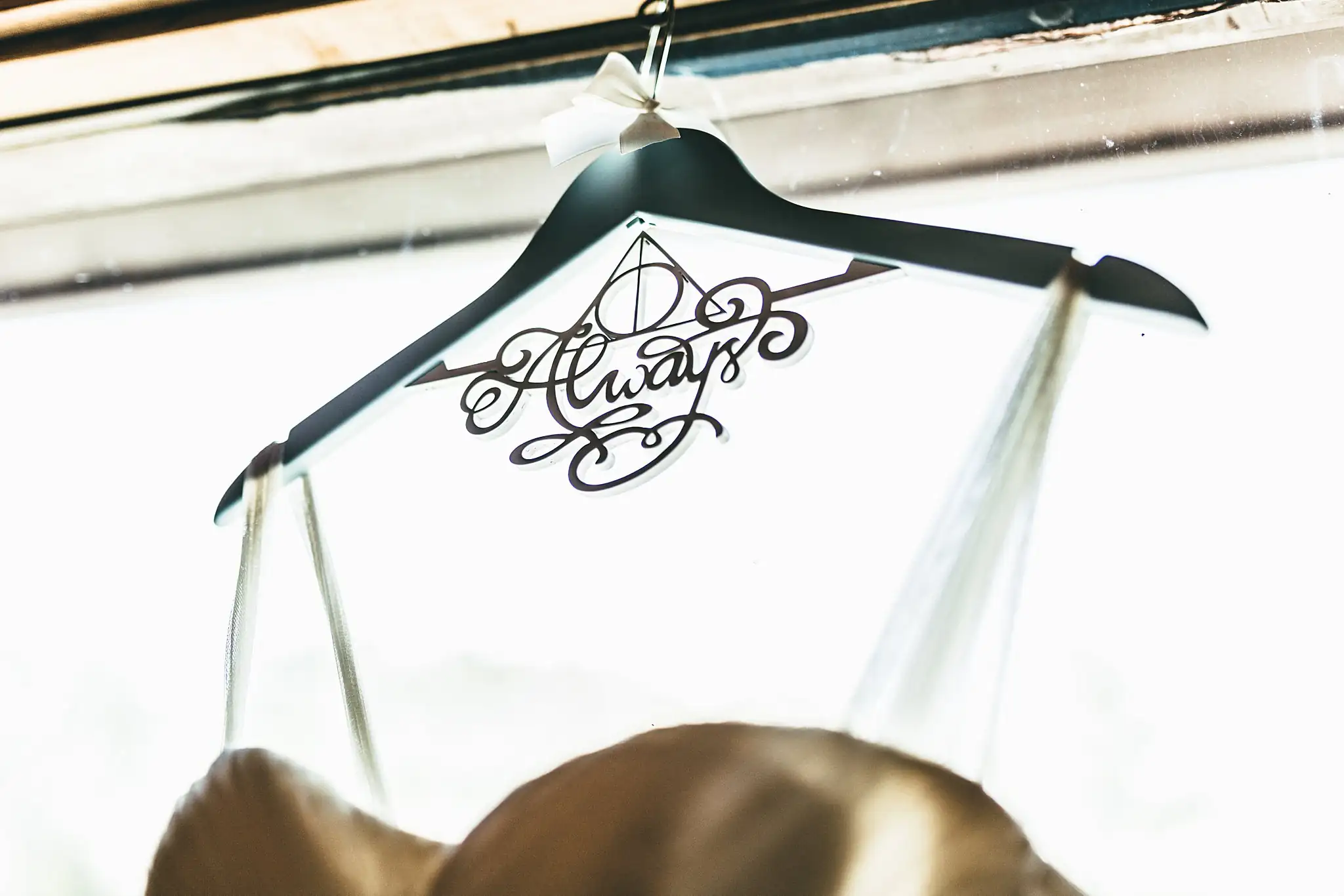 AtlantaWeddingPhotographers_1414.jpg Wedding Details: a hanger cut with the Deathly Hallows and the word Always, at a wedding at Three Birches in Alpharetta, GA