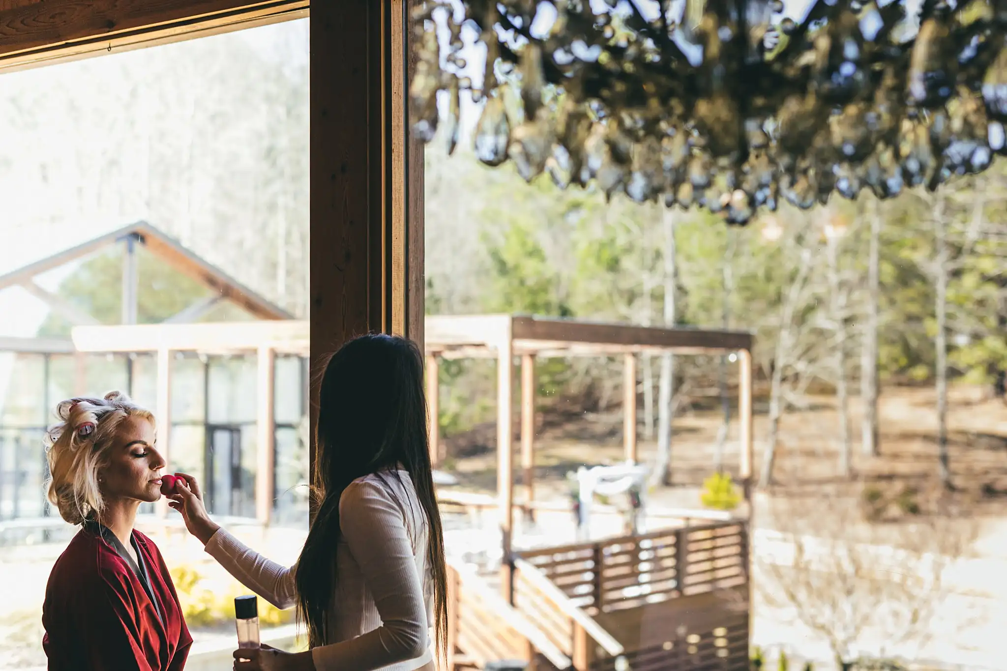 AtlantaWeddingPhotographers_1415.jpg Getting Ready: the bride having her makeup done by the windows, before their wedding at Three Birches in Alpharetta, GA