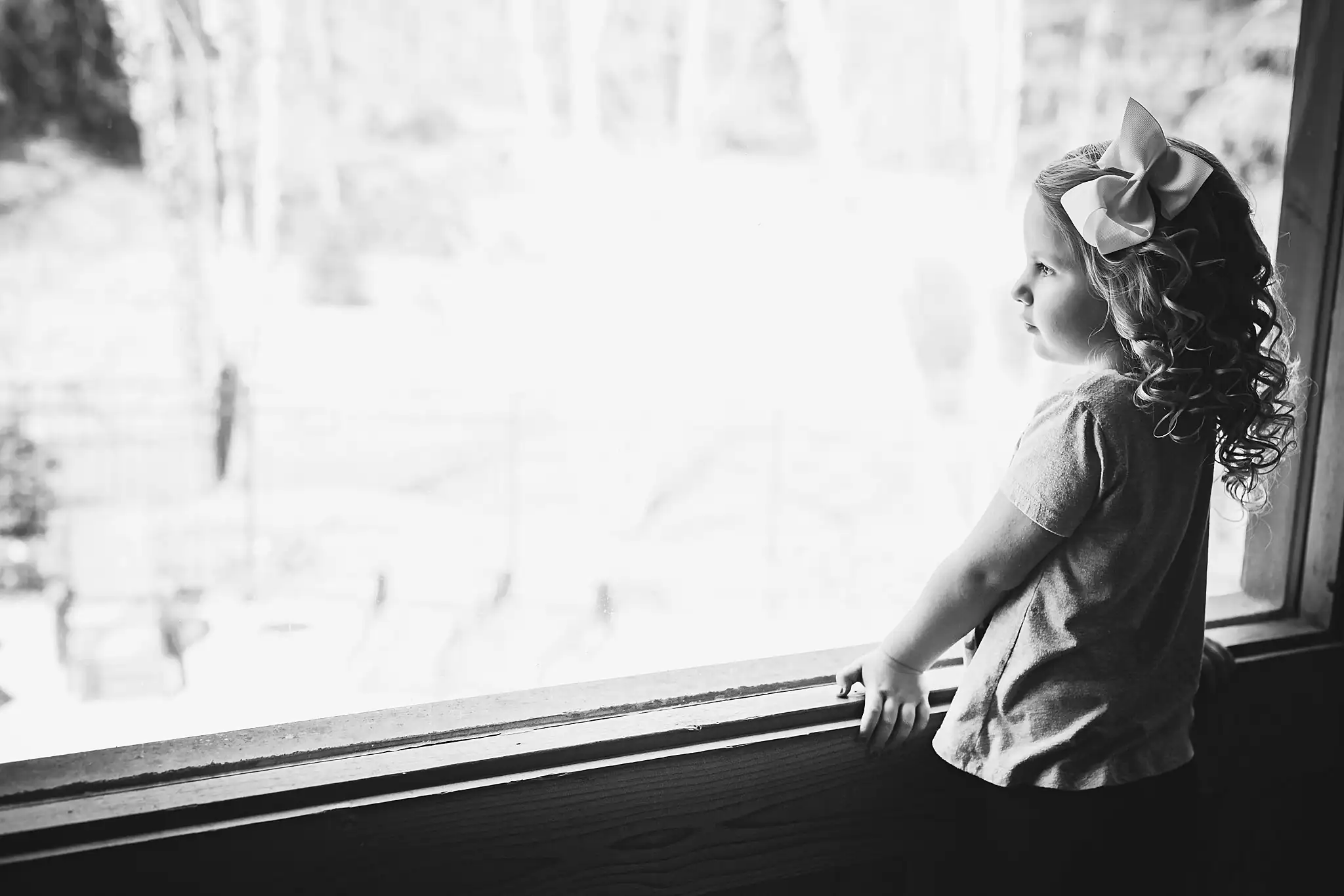 AtlantaWeddingPhotographers_1420.jpg Getting Ready: a flower girl at the window, in black and white, before their wedding at Three Birches in Alpharetta, GA