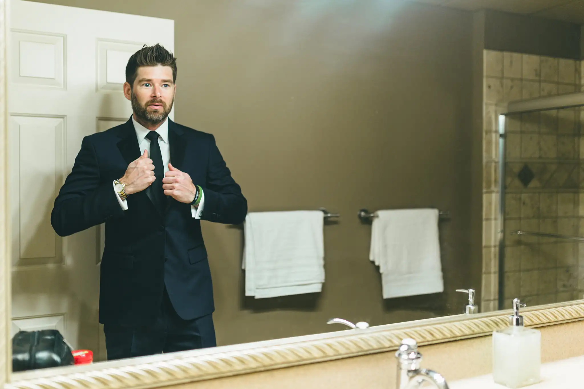 AtlantaWeddingPhotographers_1427.jpg Getting Ready: the groom at the mirror with his tie, before their wedding at Three Birches in Alpharetta, GA