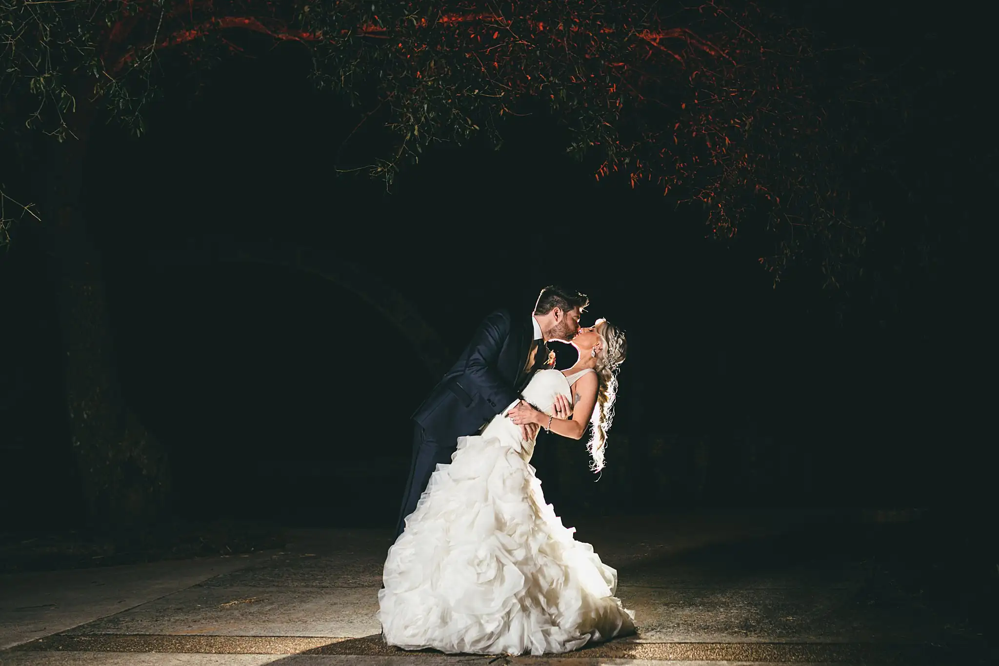 AtlantaWeddingPhotographers_1462.jpg Wedding Formals: the couple dipped and kissing, spotlit at night, at their wedding at Three Birches in Alpharetta, GA