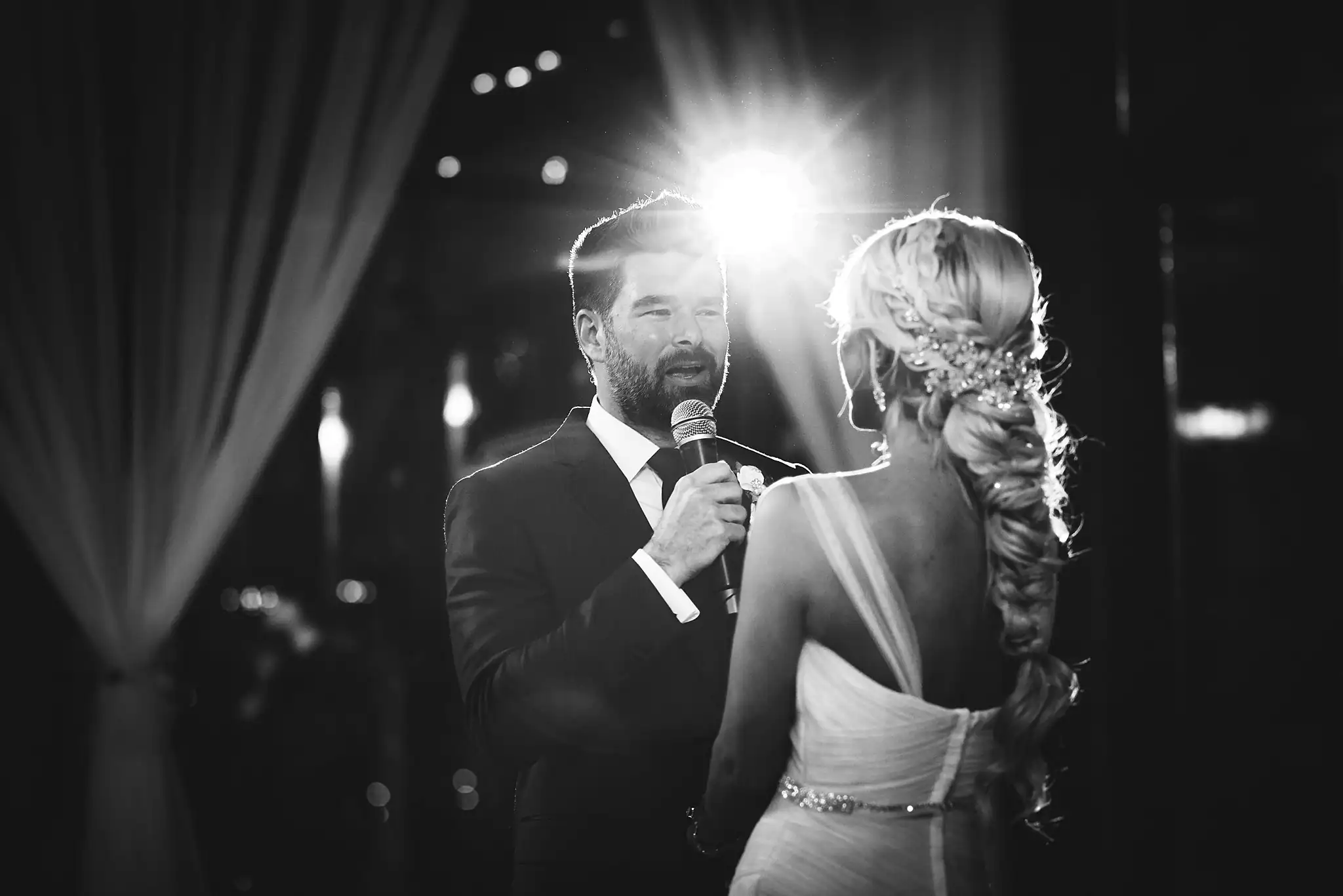AtlantaWeddingPhotographers_1482.jpg Wedding Reception: the couple at the microphone, in black and white, at their wedding at Three Birches in Alpharetta, GA