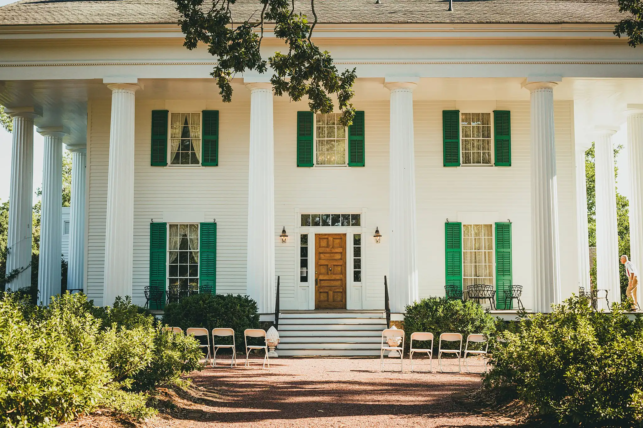 Wedding Ceremony: the columned house with chairs set on the lawn, at a micro wedding at Barrington Hall in Roswell, GA