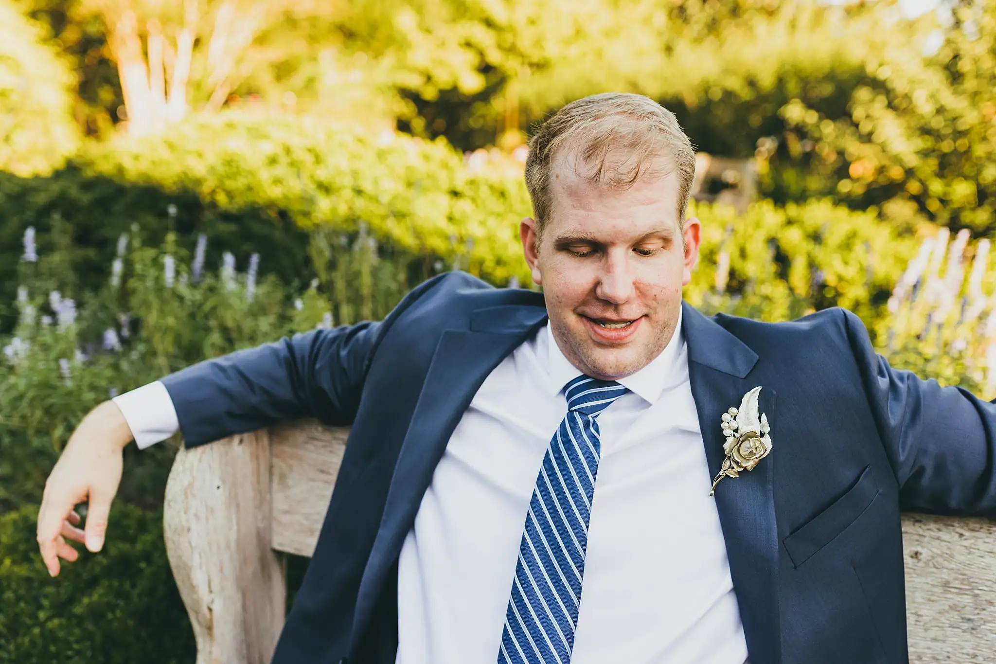 AtlantaWeddingPhotographers_1555.jpg Wedding Formals: the groom leaning back along a garden bench, at their elopement at Barrington Hall in Roswell, GA
