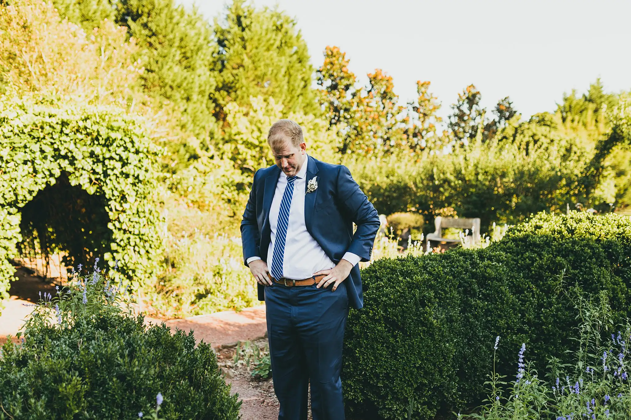 AtlantaWeddingPhotographers_1556.jpg Wedding Formals: the groom on the path by the clipped hedges, at their intimate wedding at Barrington Hall in Roswell, GA