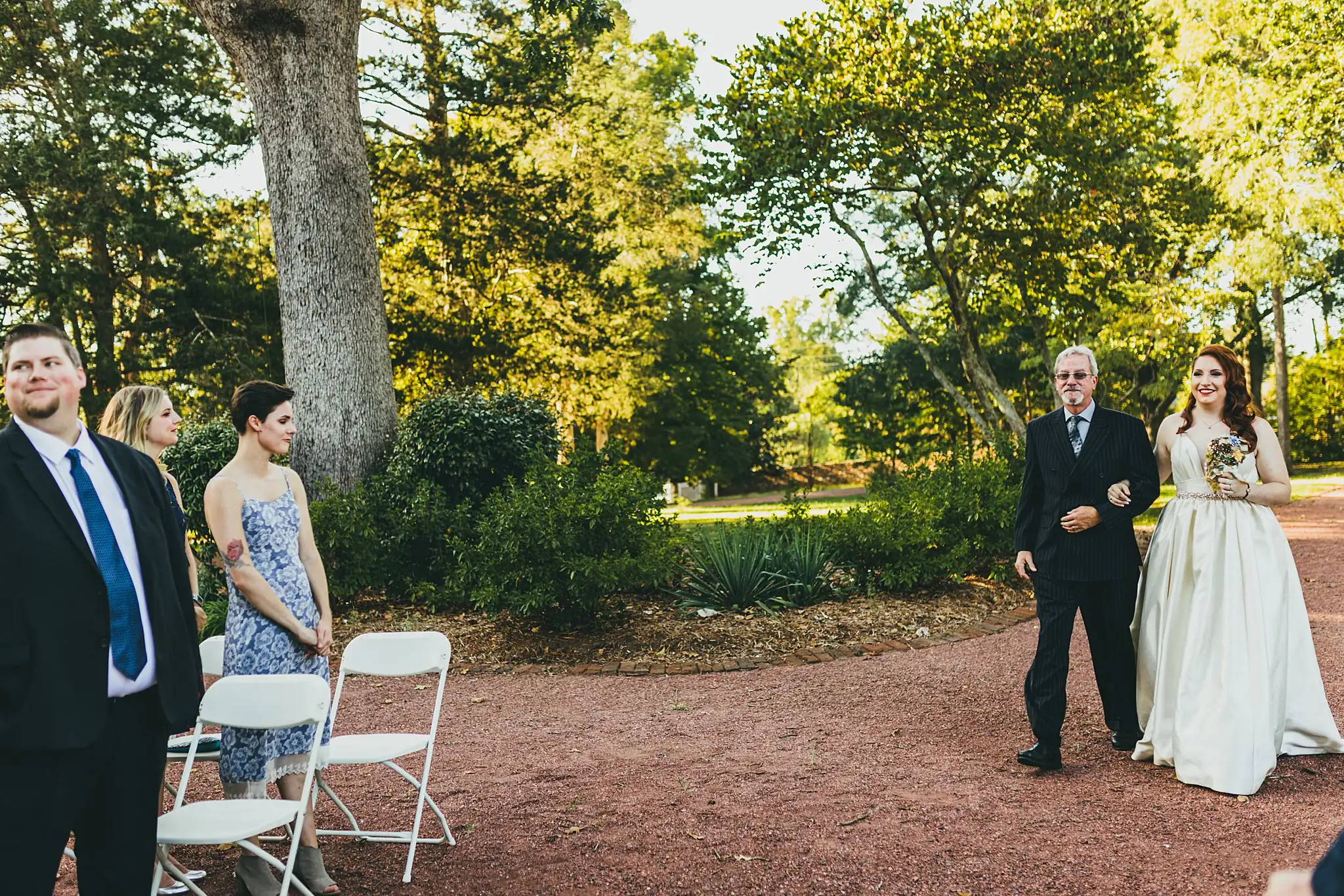 AtlantaWeddingPhotographers_1563.jpg Processional: guests rising as she comes up the path, at their micro ceremony at Barrington Hall in Roswell, GA