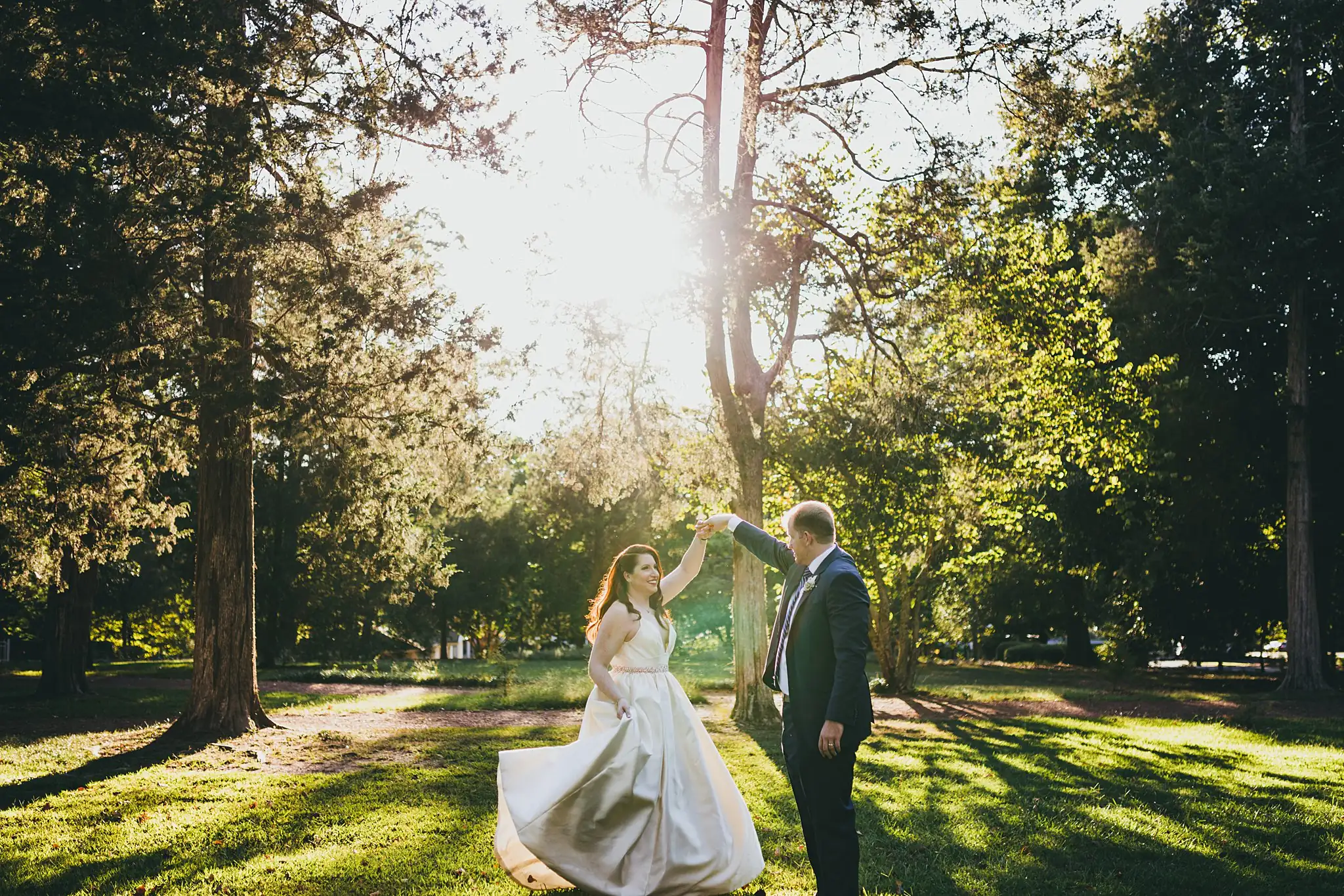 AtlantaWeddingPhotographers_1575.jpg Wedding Formals: the groom turning her under his arm in the sun, at their elopement at Barrington Hall in Roswell, GA