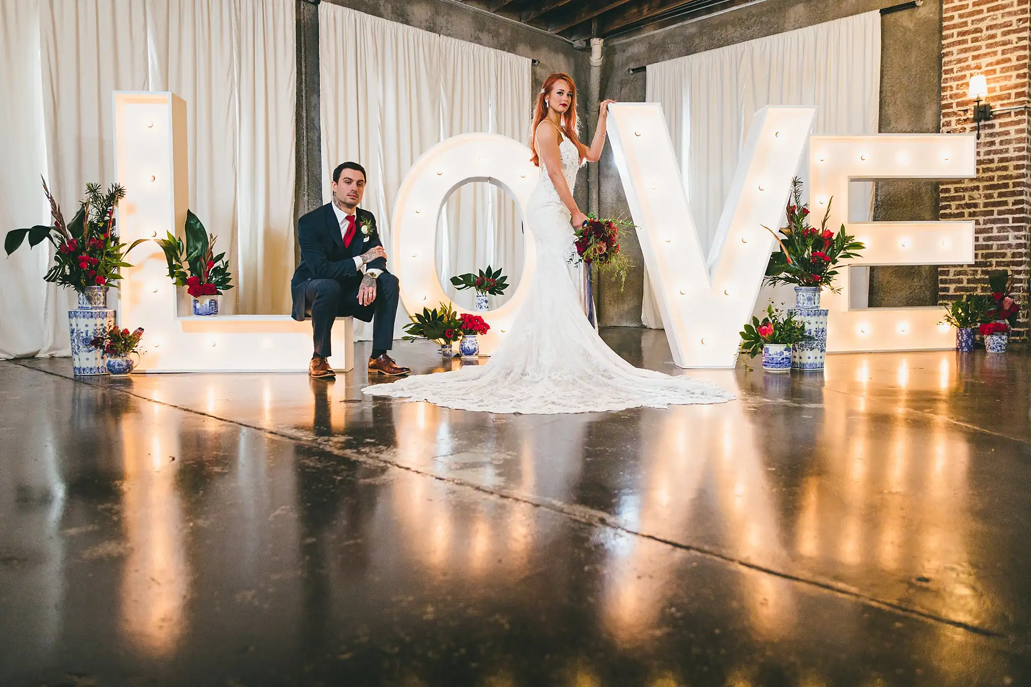 Styled Shoot Hollywood Regency Wedding Inspiration Atlanta Photographers Wedding Formals: the couple posed across the lit LOVE letters, at a Hollywood Regency Wedding styled shoot at the Foxglove in Marietta, GA