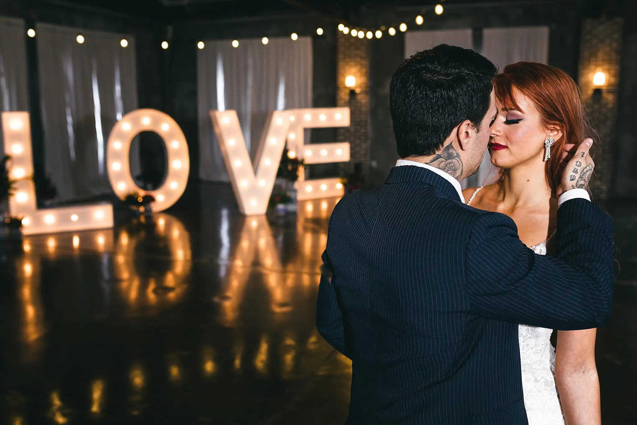 Styled Shoot Hollywood Regency Wedding Inspiration Atlanta Photographers First Dance: the couple kissing before the lit LOVE letters, at a Hollywood Regency Wedding styled shoot at the Foxglove in Marietta, GA