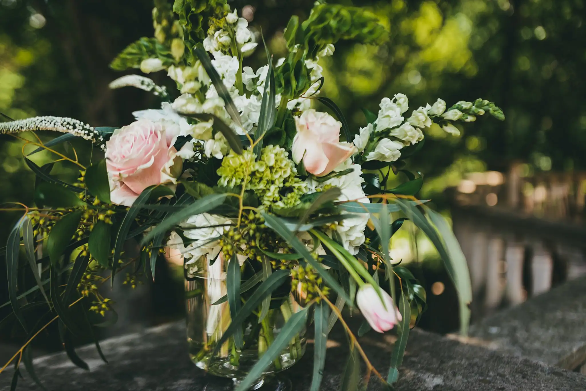Wedding Florals: a blush and white arrangement on a stone ledge, at a wedding at the Atlanta Botanical Garden in Atlanta, GA