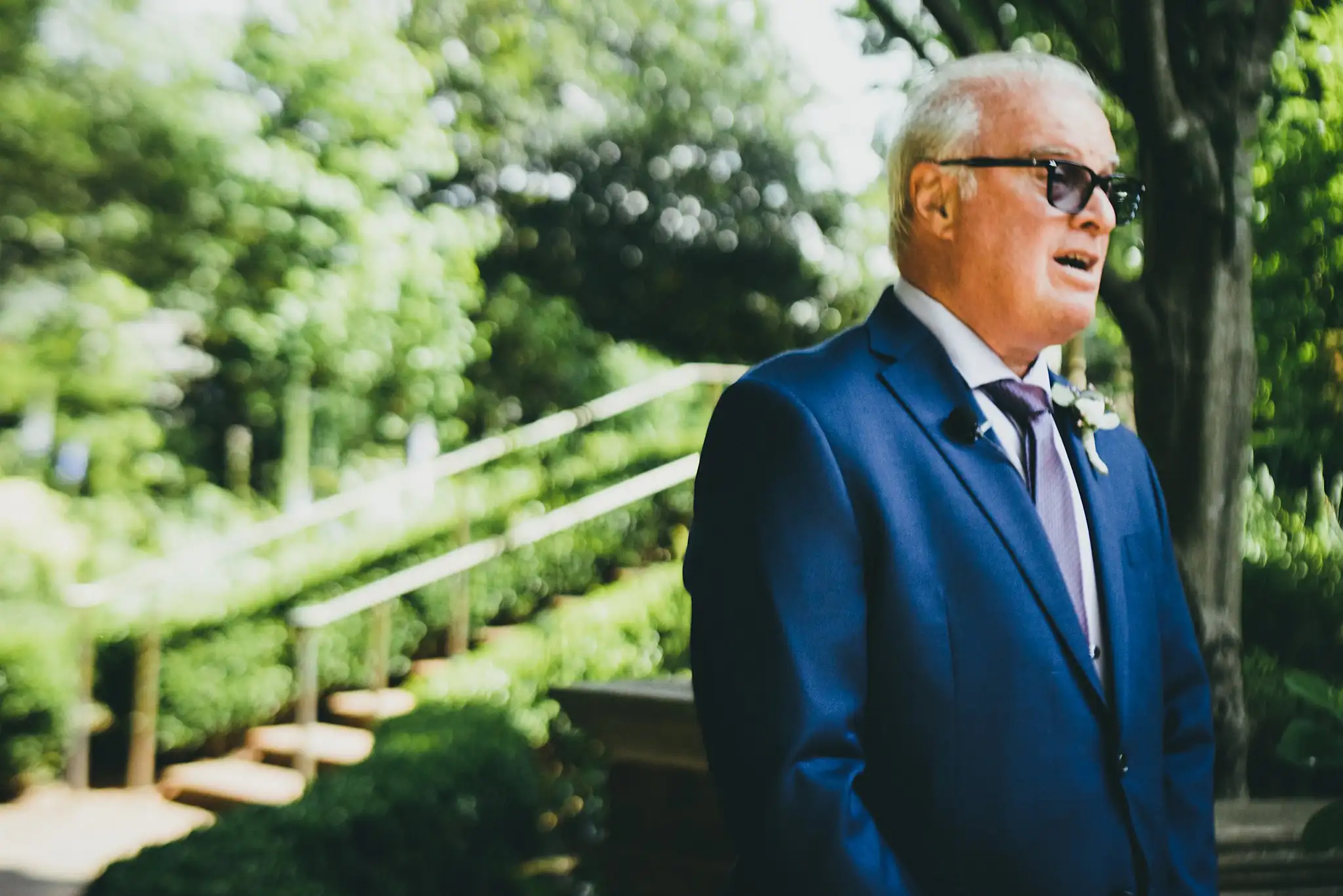 Processional: the bride's father waiting in his blue suit, at their wedding at the Atlanta Botanical Garden in Atlanta, GA