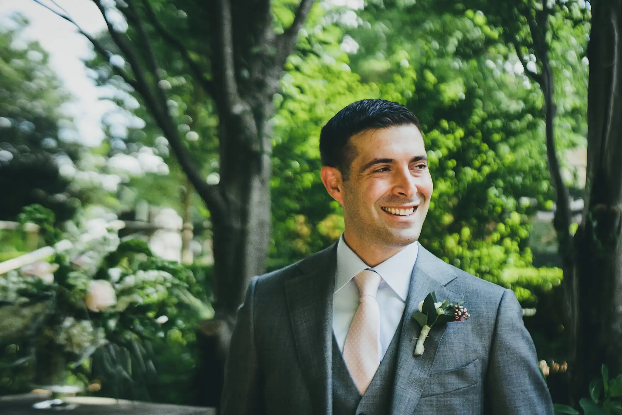 Wedding Formals: the groom smiling in his grey suit, at their wedding at the Atlanta Botanical Garden in Atlanta, GA