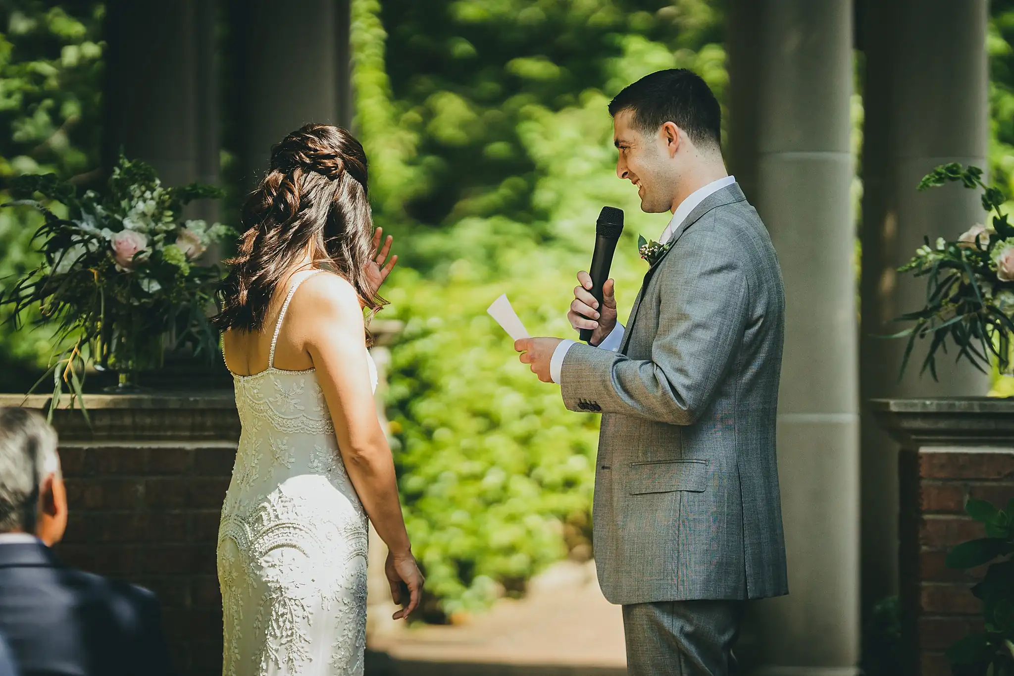 Wedding Ceremony: the groom reading his vows aloud, at their wedding at the Atlanta Botanical Garden in Atlanta, GA