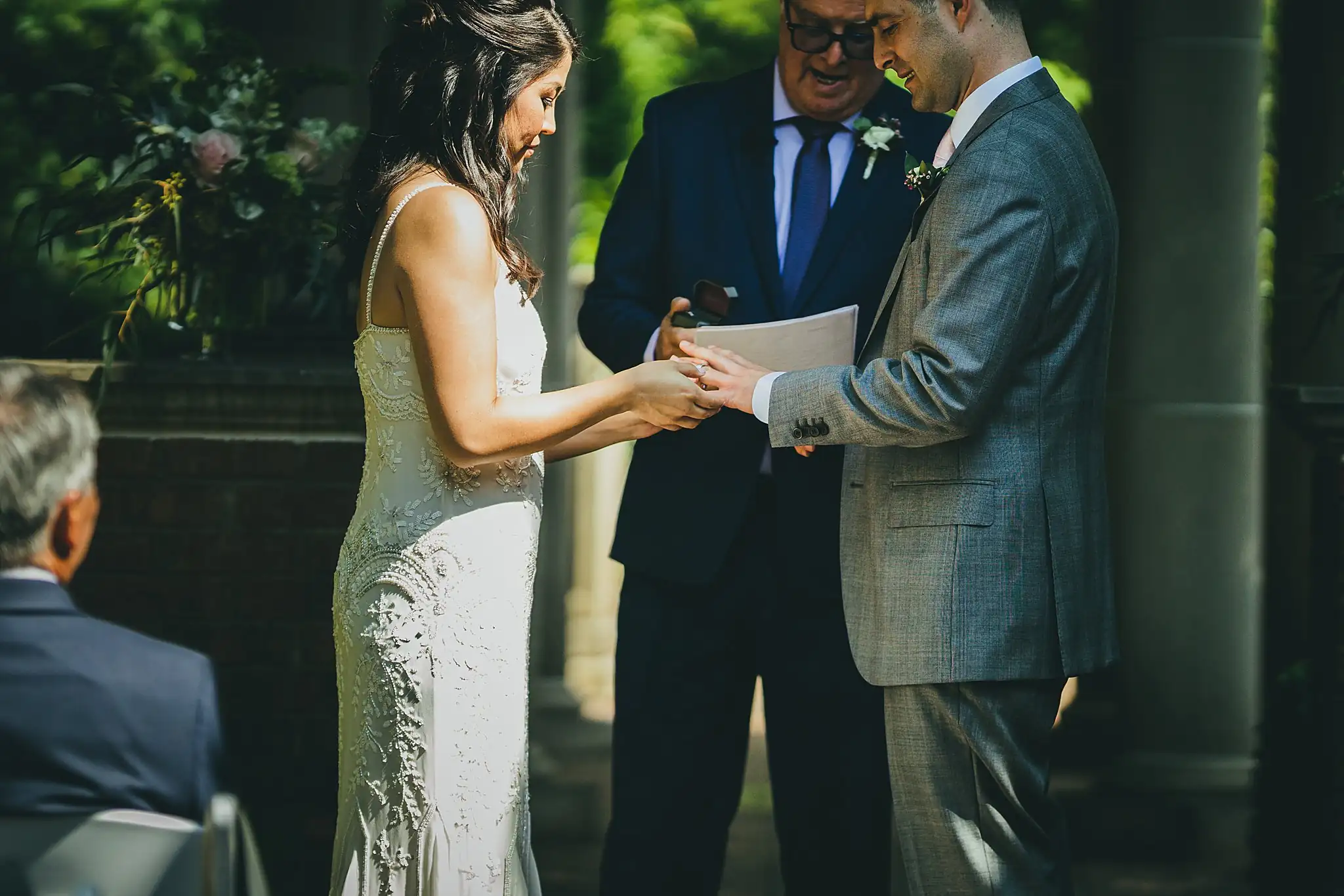 Wedding Ceremony: the couple holding hands, rings on, at their wedding at the Atlanta Botanical Garden in Atlanta, GA