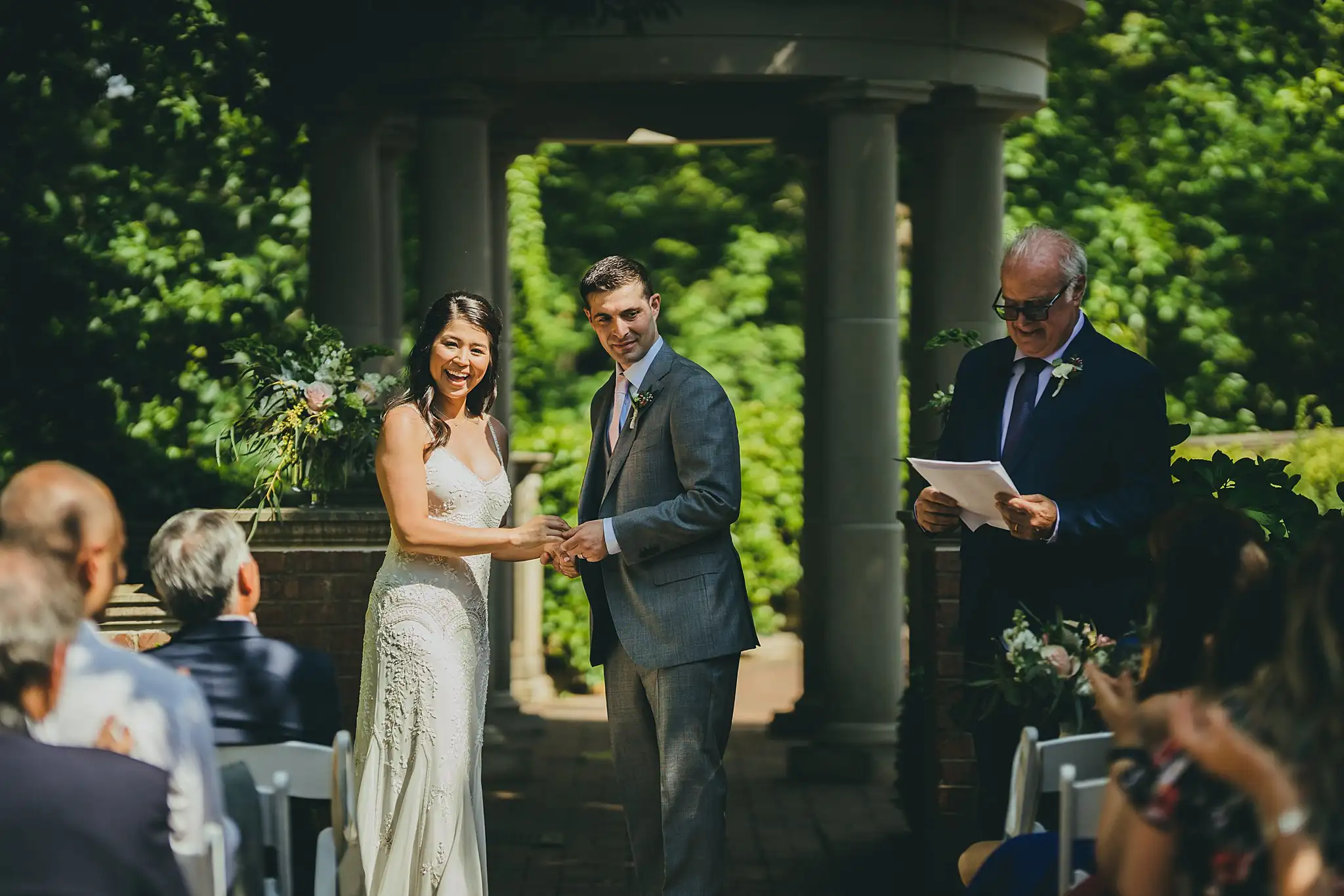 Wedding Ceremony: the couple with the officiant after the kiss, at their wedding at the Atlanta Botanical Garden in Atlanta, GA