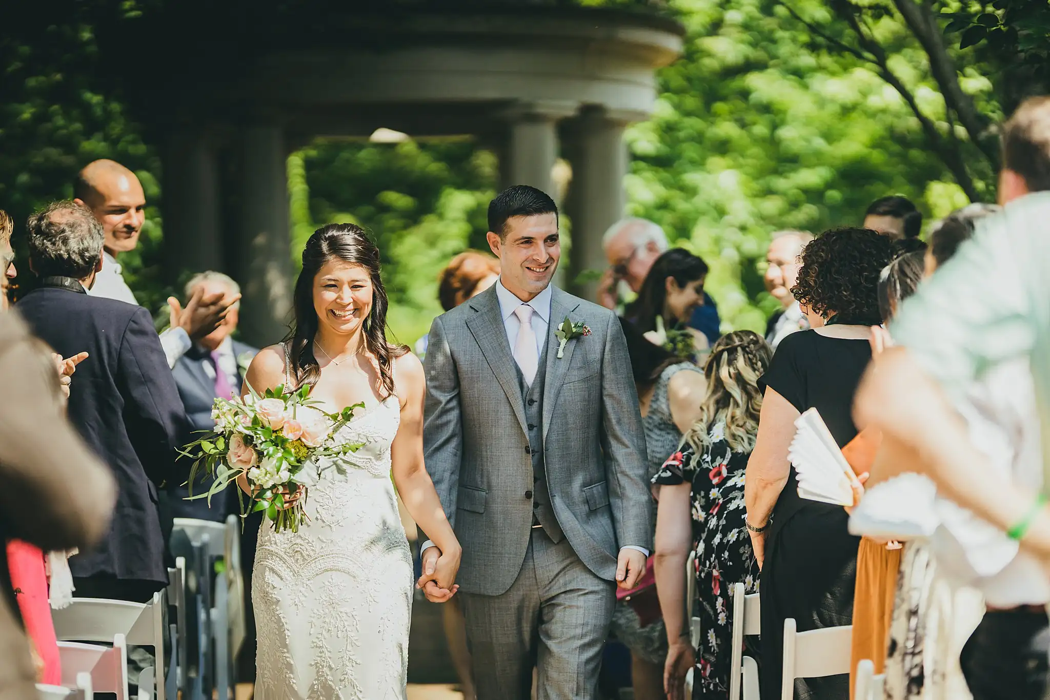 Recessional: the couple walking out through their guests, at their wedding at the Atlanta Botanical Garden in Atlanta, GA