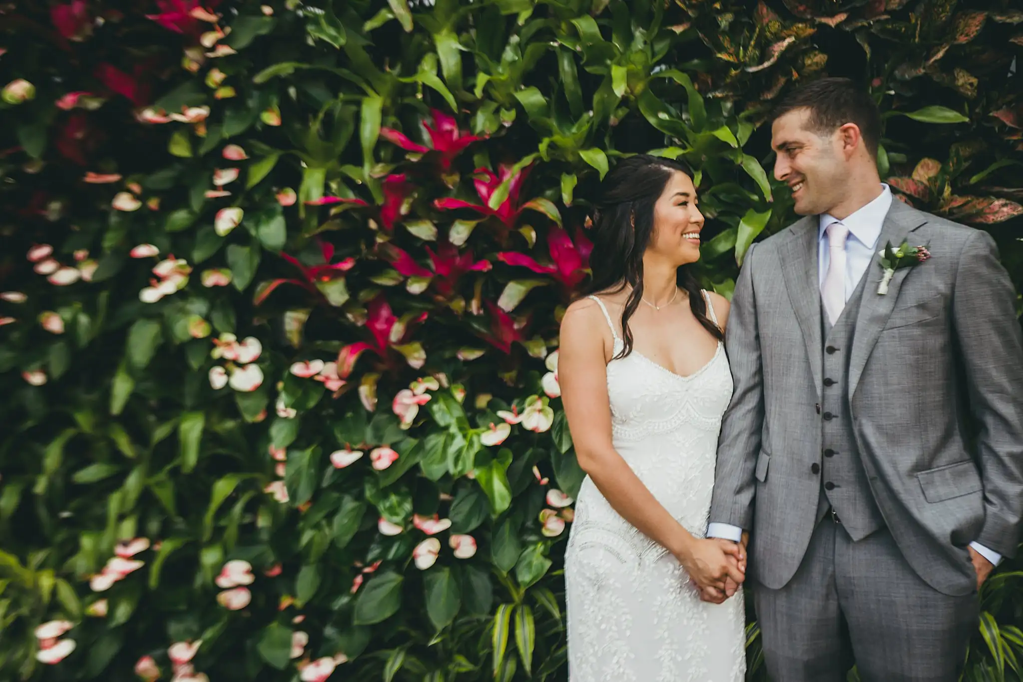 Wedding Formals: the couple holding hands at a flowering wall, at their wedding at the Atlanta Botanical Garden in Atlanta, GA