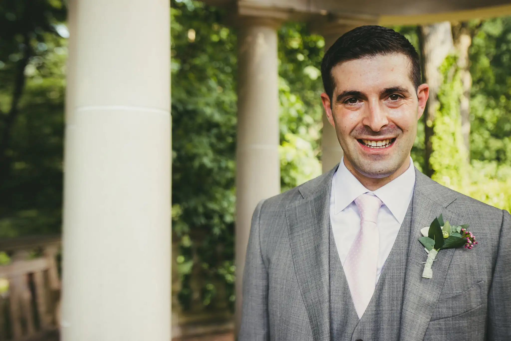 Wedding Formals: the groom against a stone column, at their wedding at the Atlanta Botanical Garden in Atlanta, GA