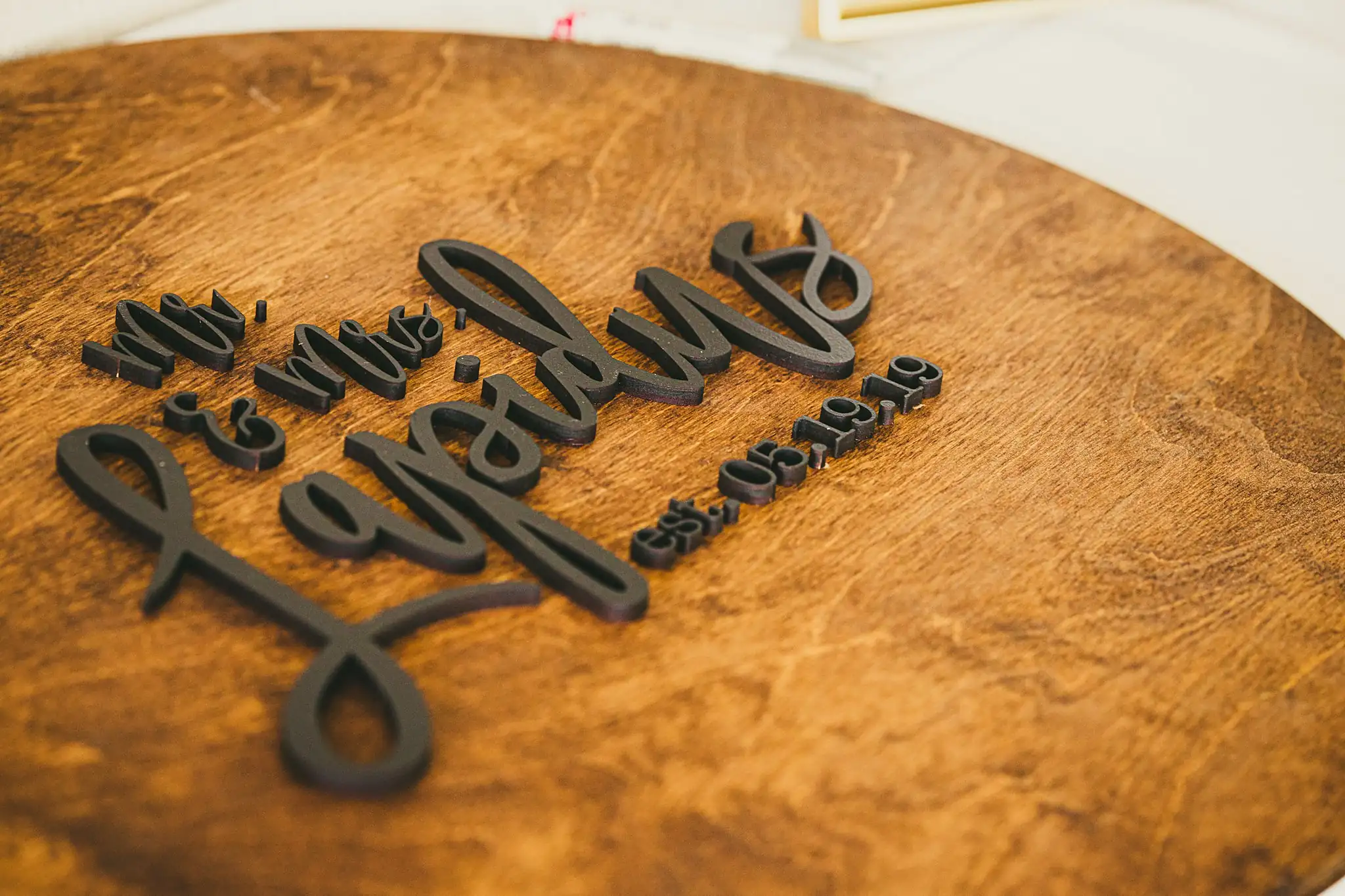 Reception Details: a carved wooden sign on a round board, at their wedding at the Atlanta Botanical Garden in Atlanta, GA