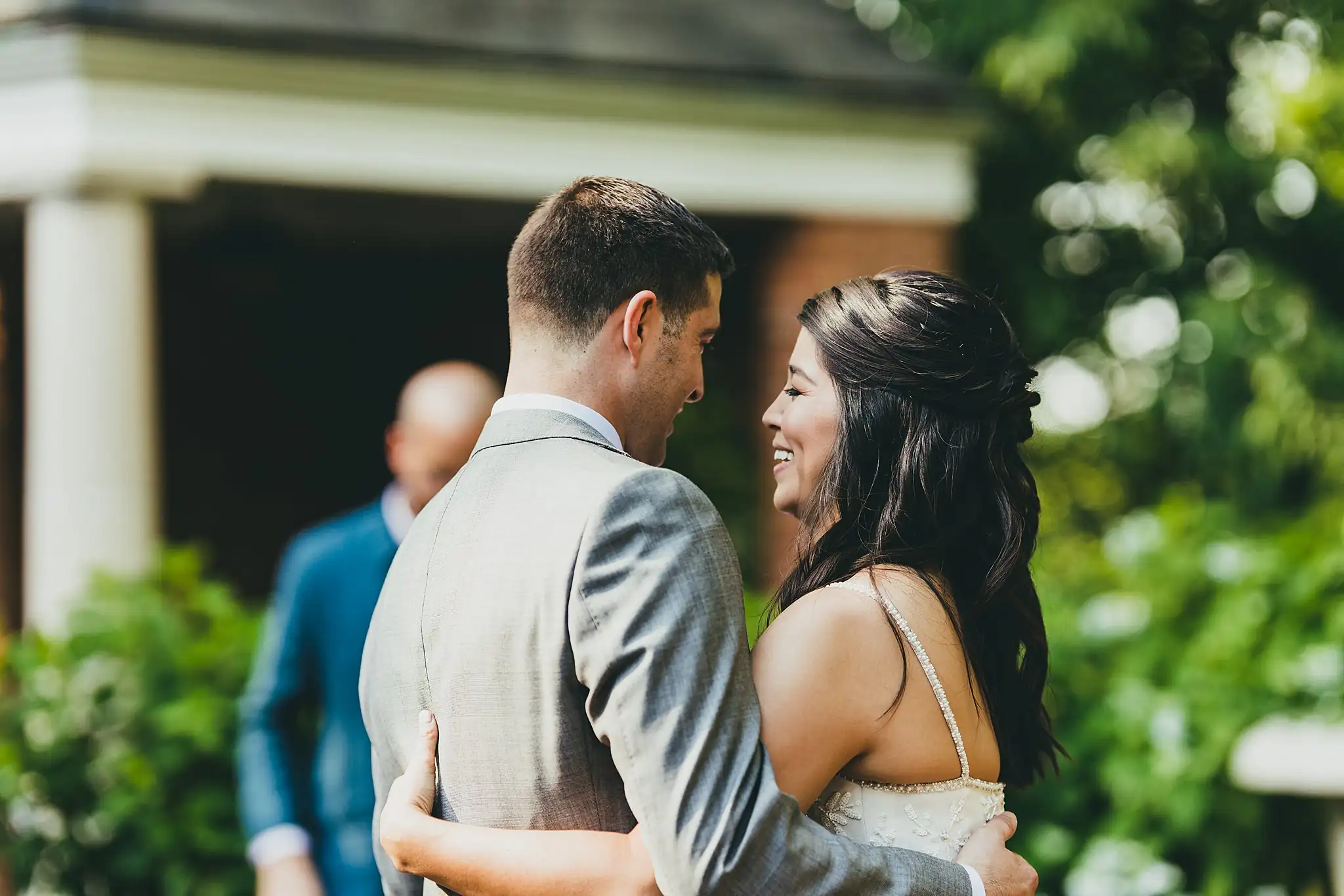 First Dance: the couple dancing, seen past a guest, at their wedding at the Atlanta Botanical Garden in Atlanta, GA