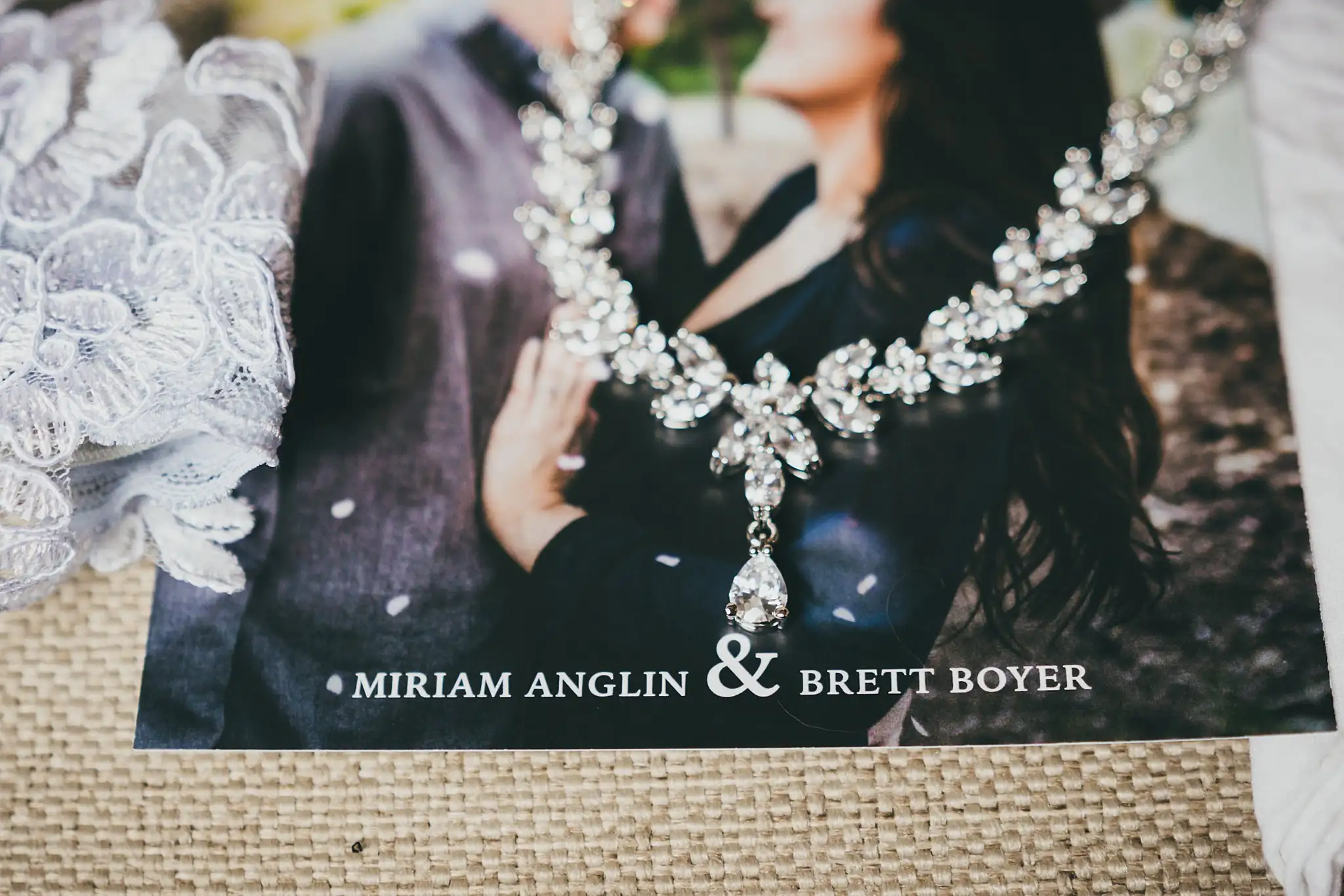 Barn at Harper Pines Wedding Thomaston, GA Atlanta Wedding Photographers Wedding Details: a crystal necklace resting on the invitation, at a wedding at the Barn at Harper Pines in Thomaston, GA